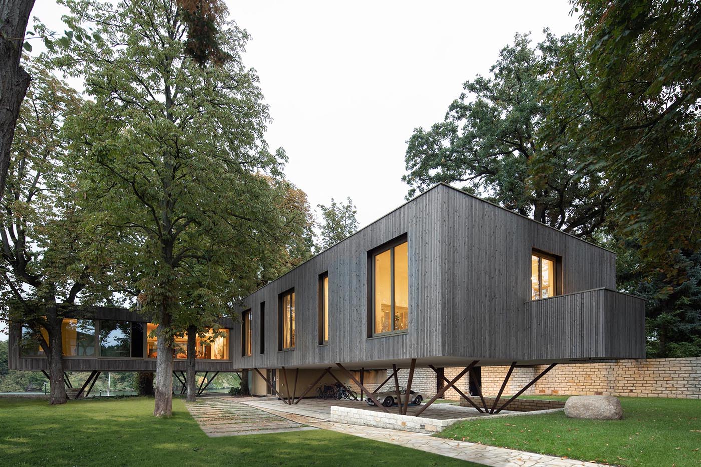 A modern house on poles has an exterior of vertical larch slats.