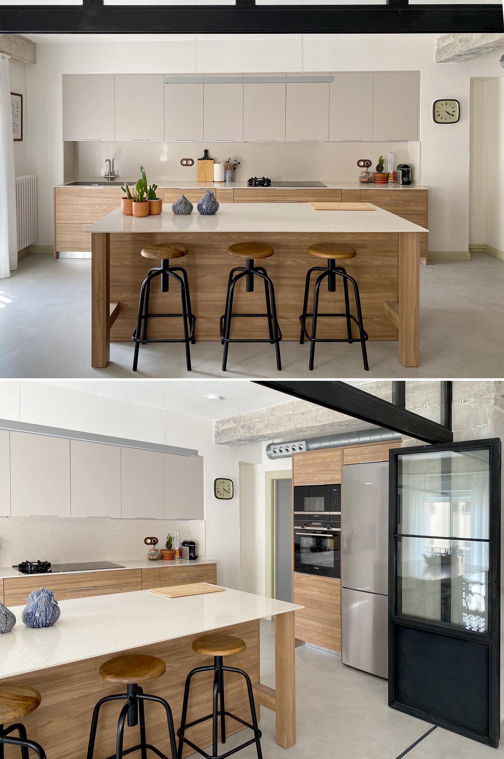 The black framed wall also complements the black stools of the kitchen island, while the kitchen cabinets have a minimalist design.