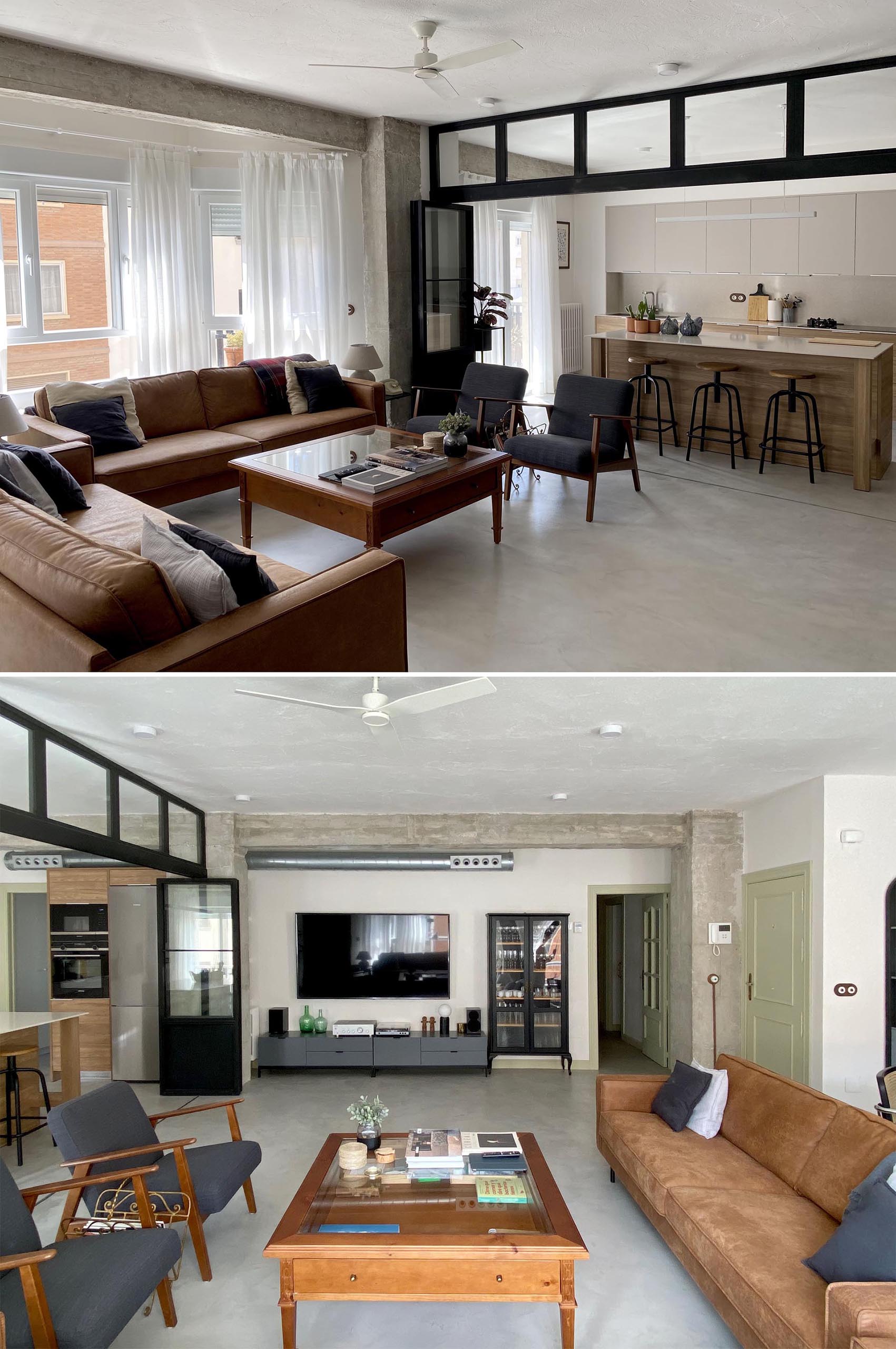 This modern living room showcases the concrete flooring, and is furnished with leather couches, a pair of armchairs, and a wood coffee table. On the living room wall, there's a low console and glass front cabinet that complements the black framed doors.