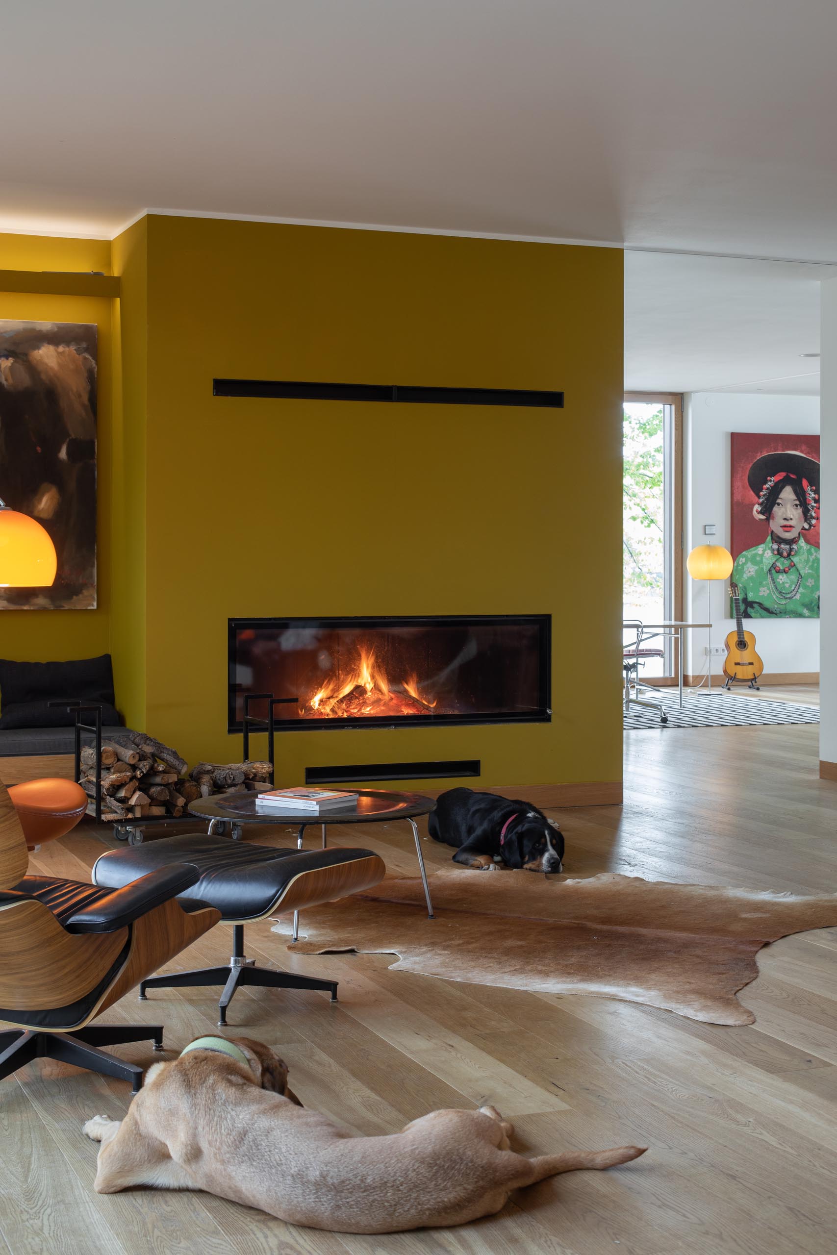 A modern linear fireplace with a mustard colored surround.