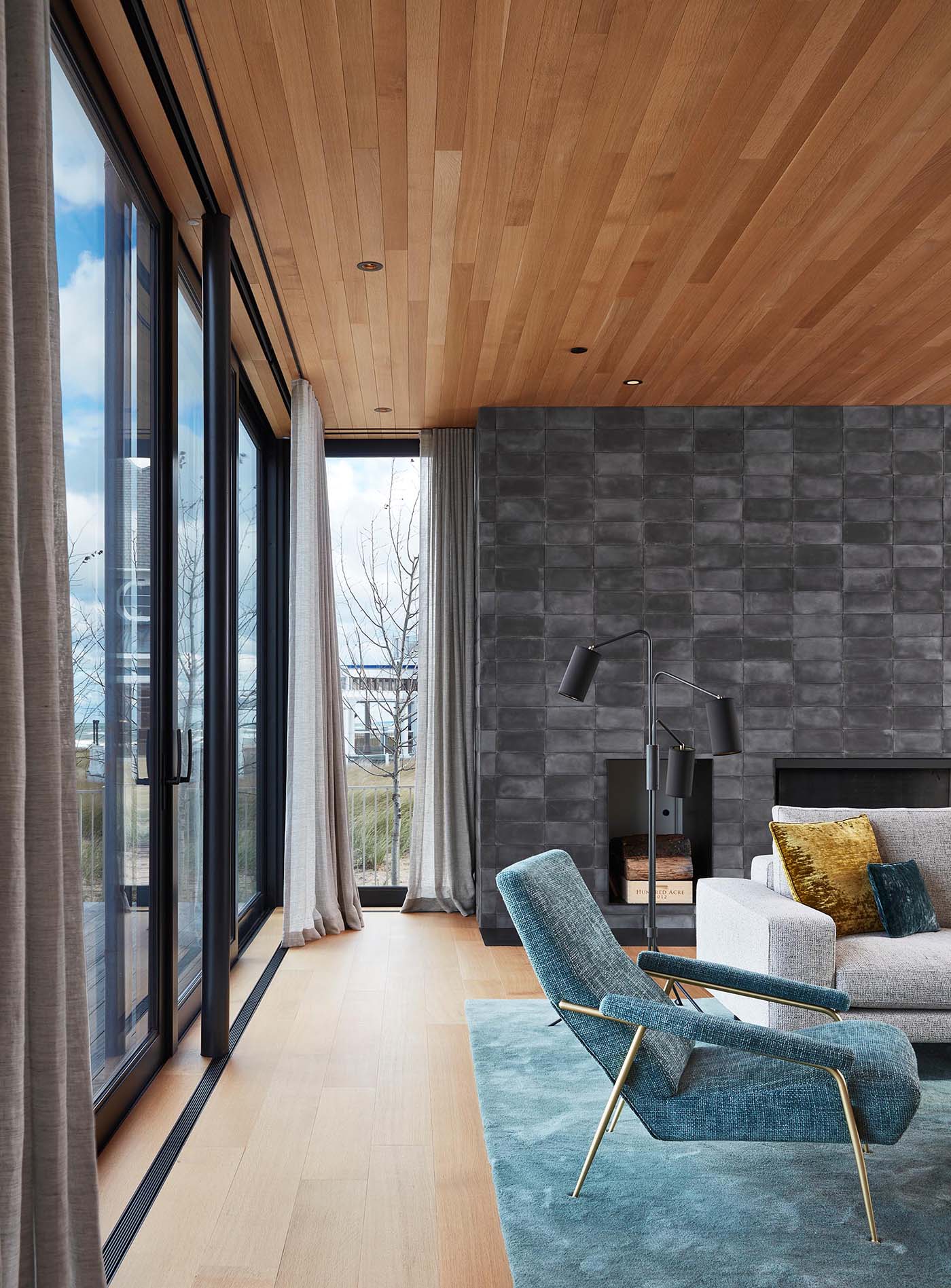 The interiors of the home include white oak wood ceilings that are featured throughout the main floor, like in the living room.