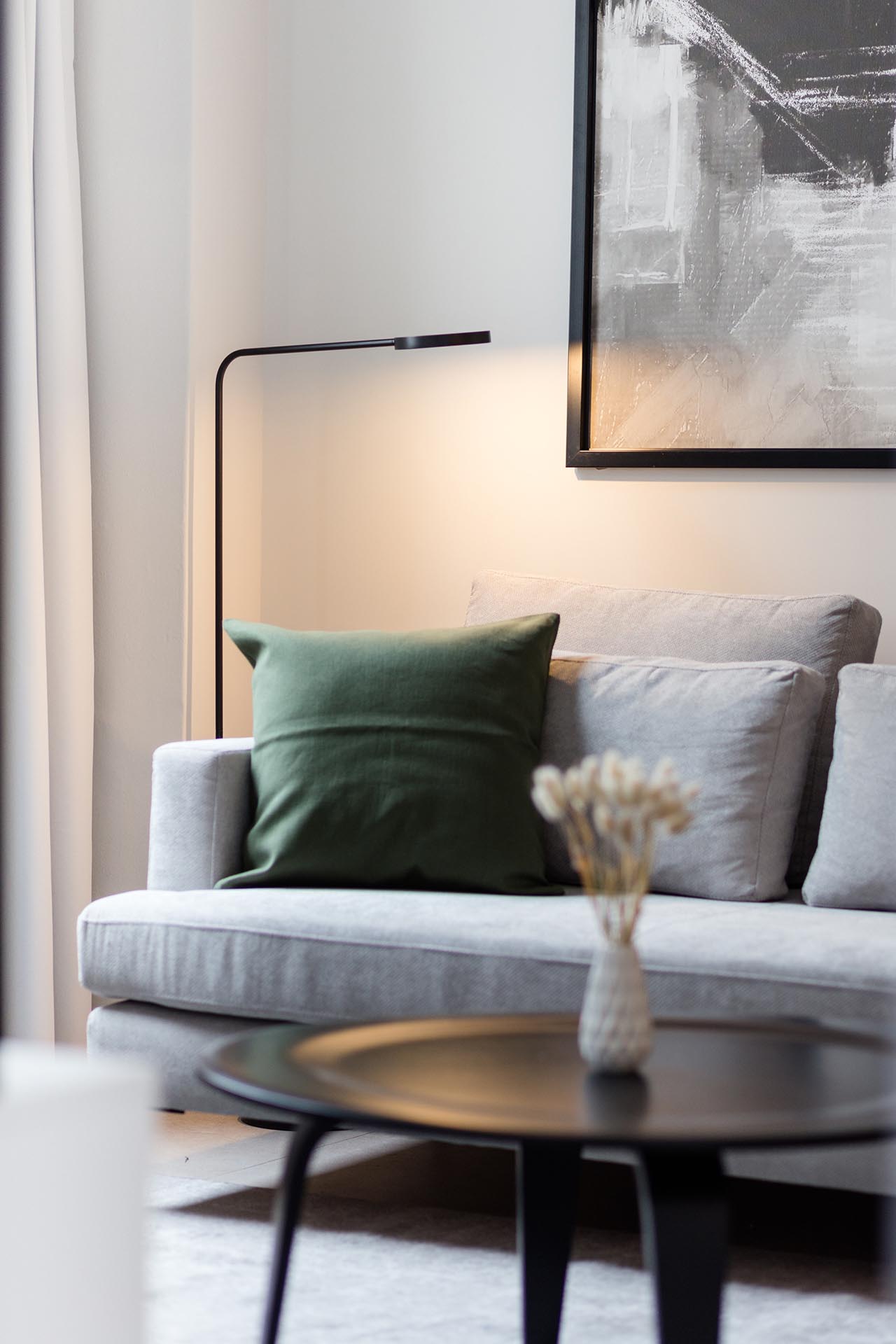 The living room includes contemporary furniture with tall floor-to-ceiling curtains and minimalist black lighting.