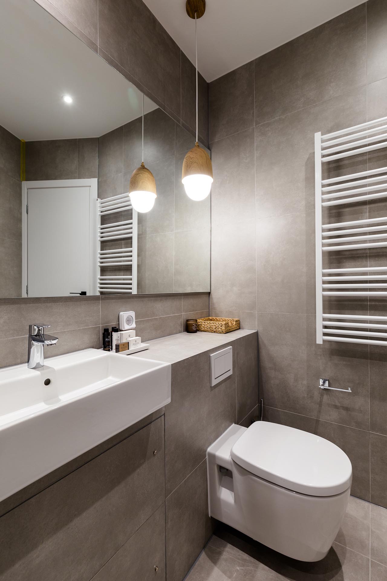 A small and modern bathroom with large format gray tiles.