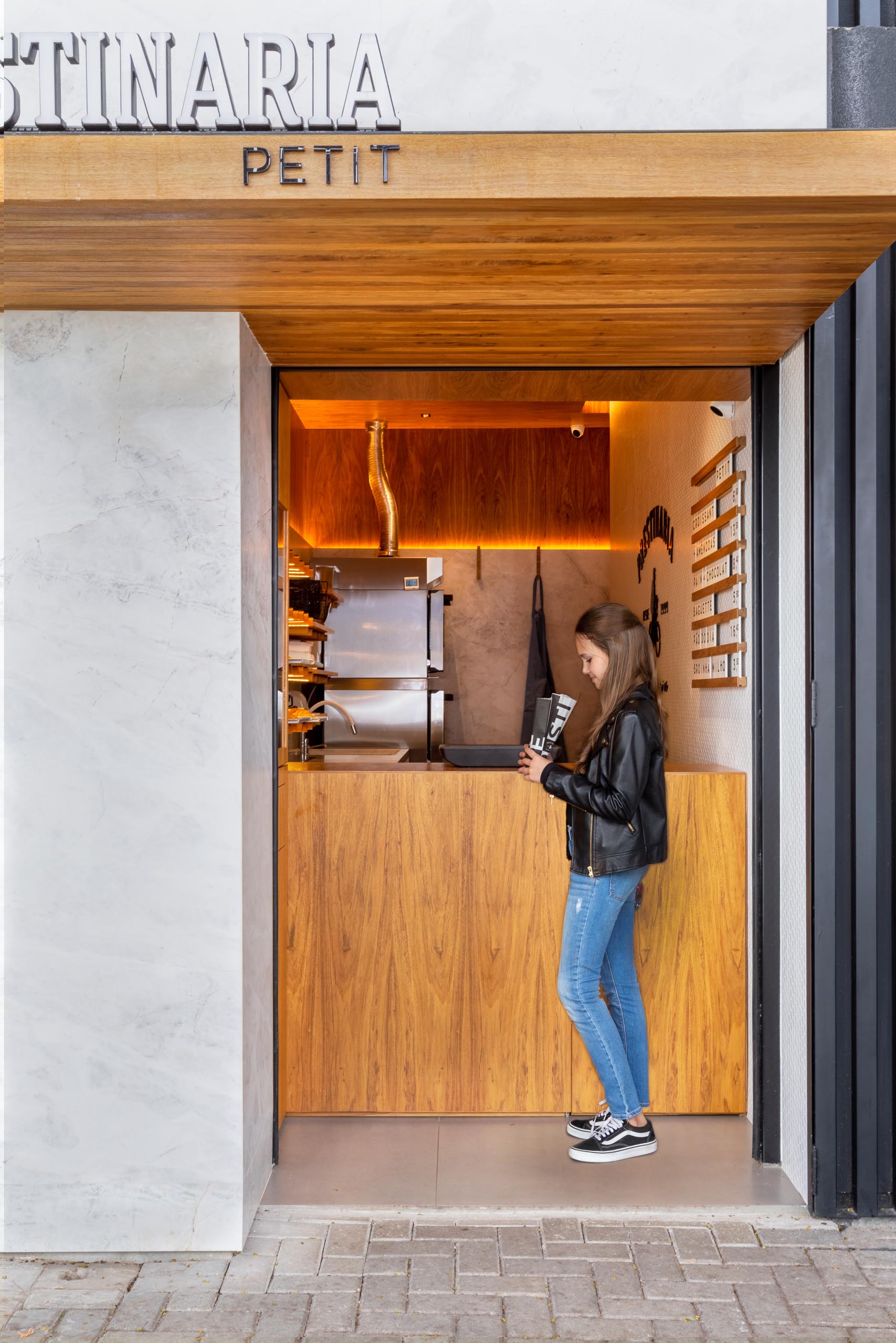 A small bakery makes use of wood dowels with hidden LED lighting to hold up shelving.