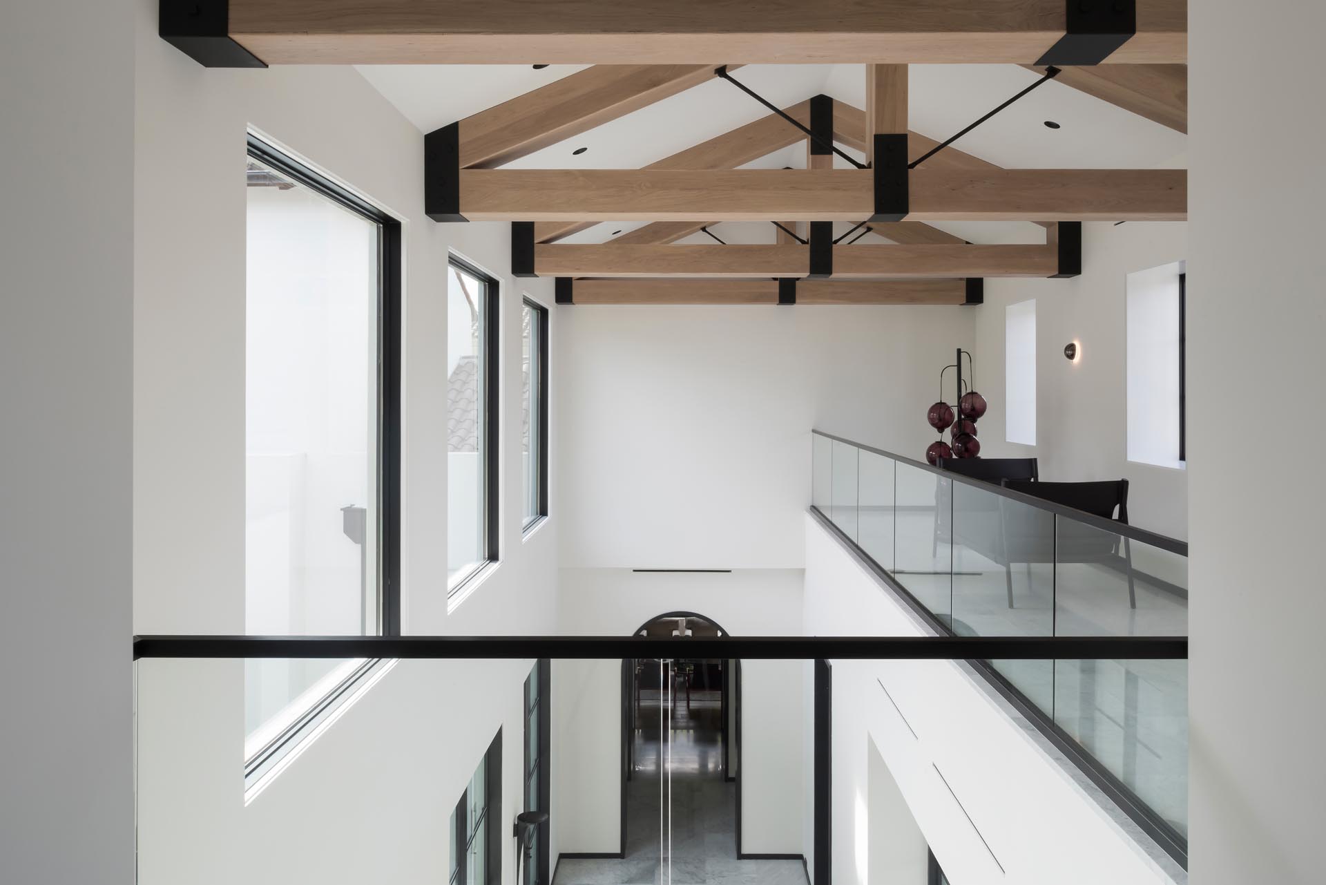 Exposed wood trusses add a natural element to the space, while the black supports match the window frames, doorways, and handrails.