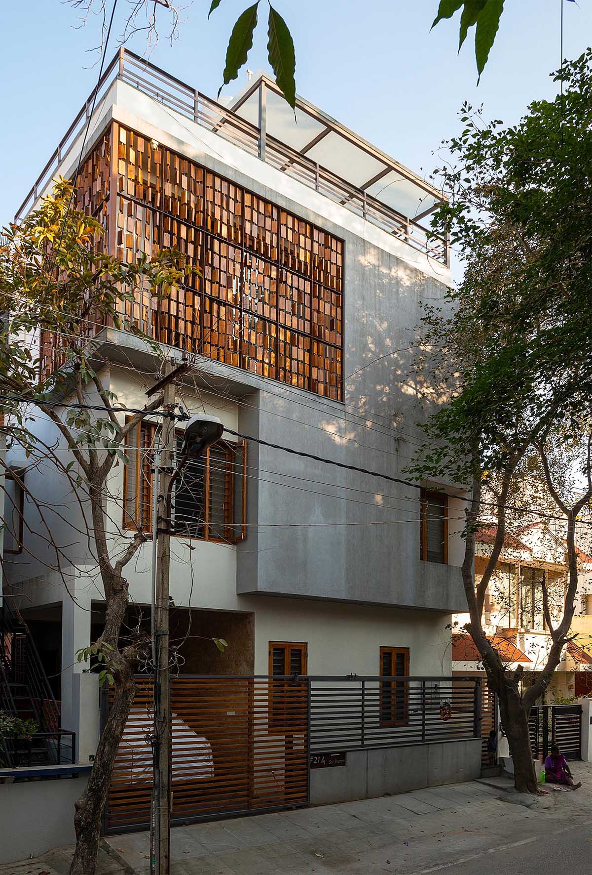 A modern house with a wood block screen that wraps around the corner of the home.