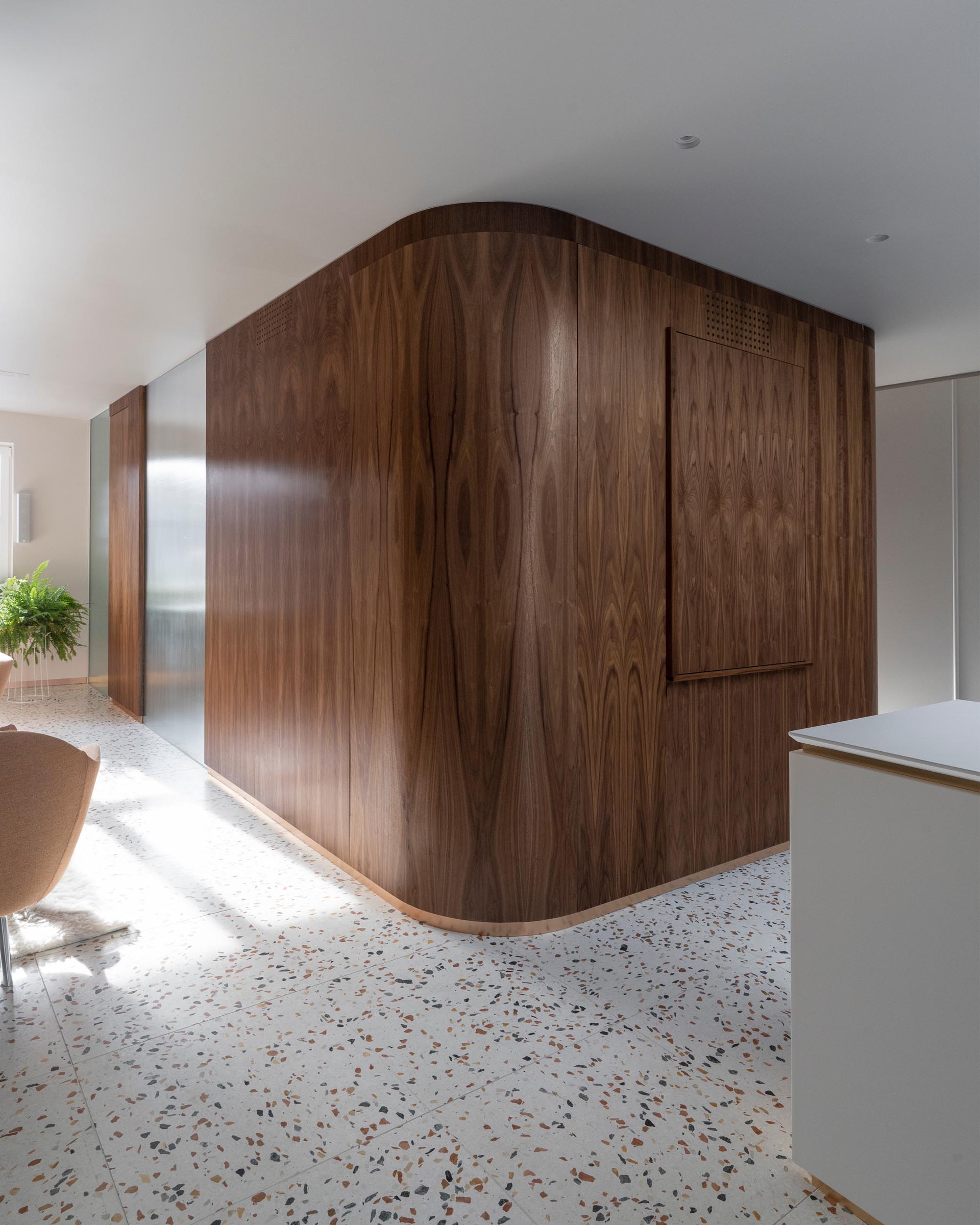 Connecting the various levels of this modern home is a central module clad in walnut that houses the staircase and a small powder room.