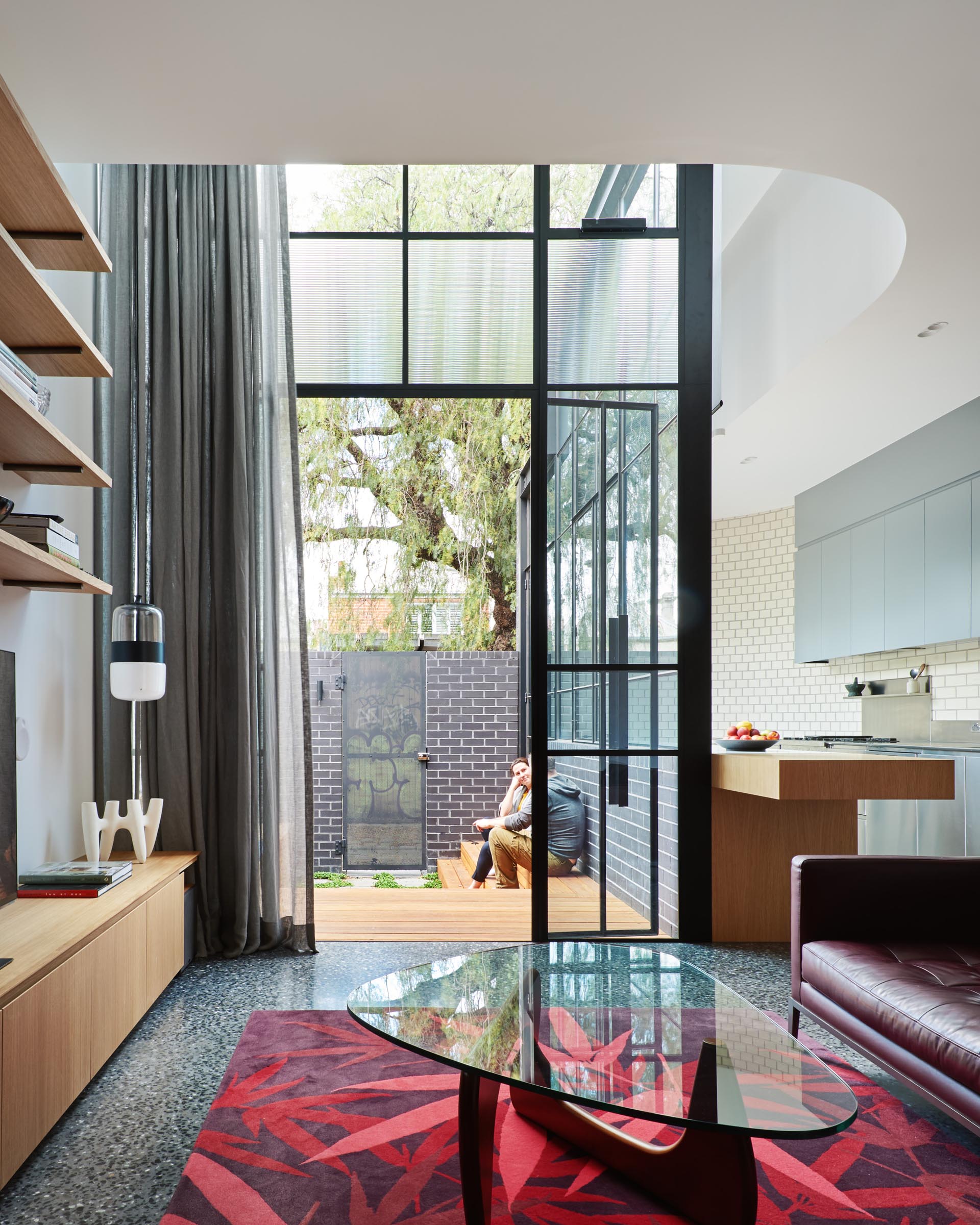 Black blinds and gray curtains can be closed for privacy when needed in this house addition with glass walls.