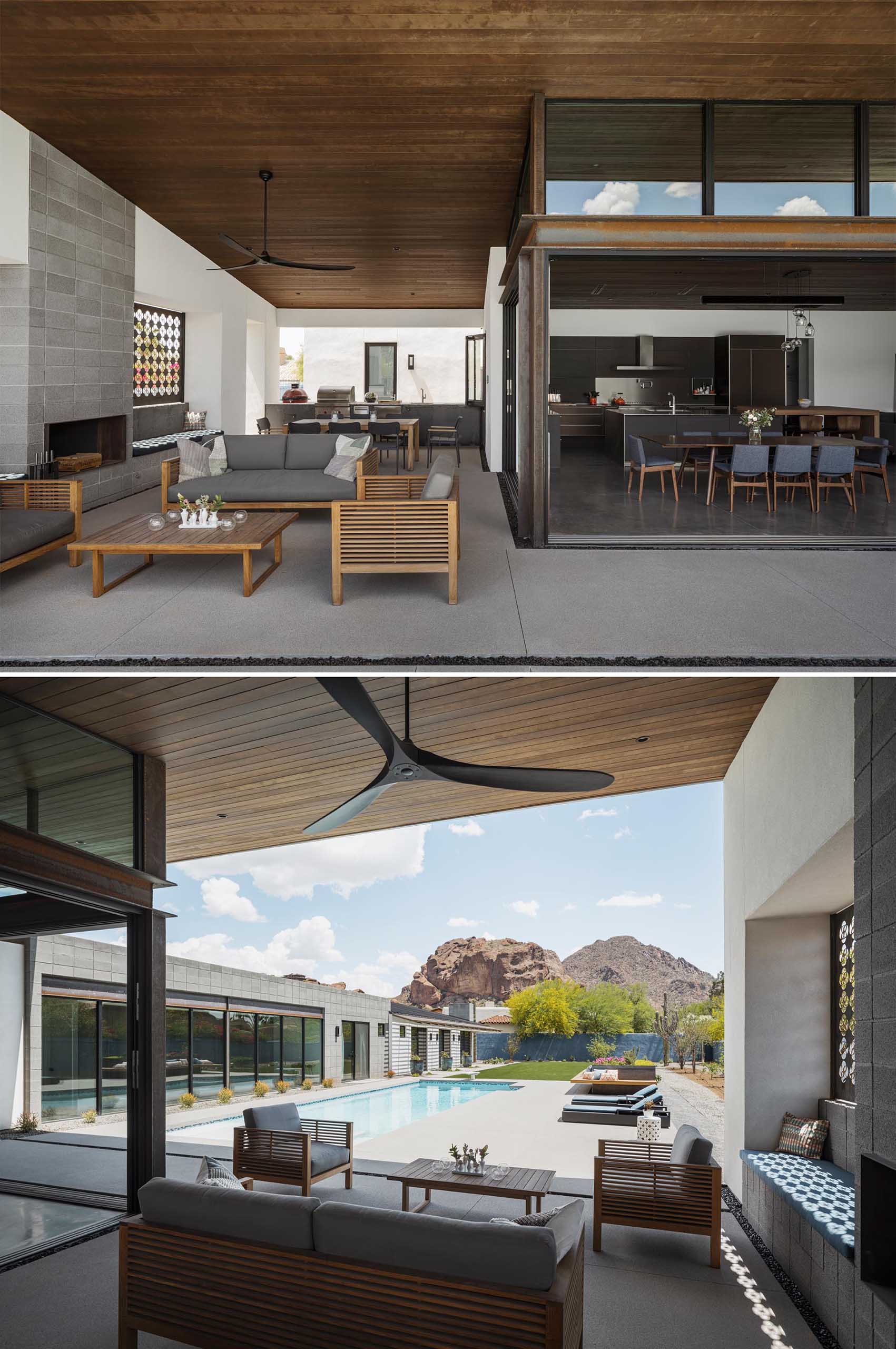 This modern covered patio includes a fireplace that is also used for cooking, built-in benches that flank the fireplace, an outdoor kitchen and dining area, a lounge area, and a customized screen with their family emblem.