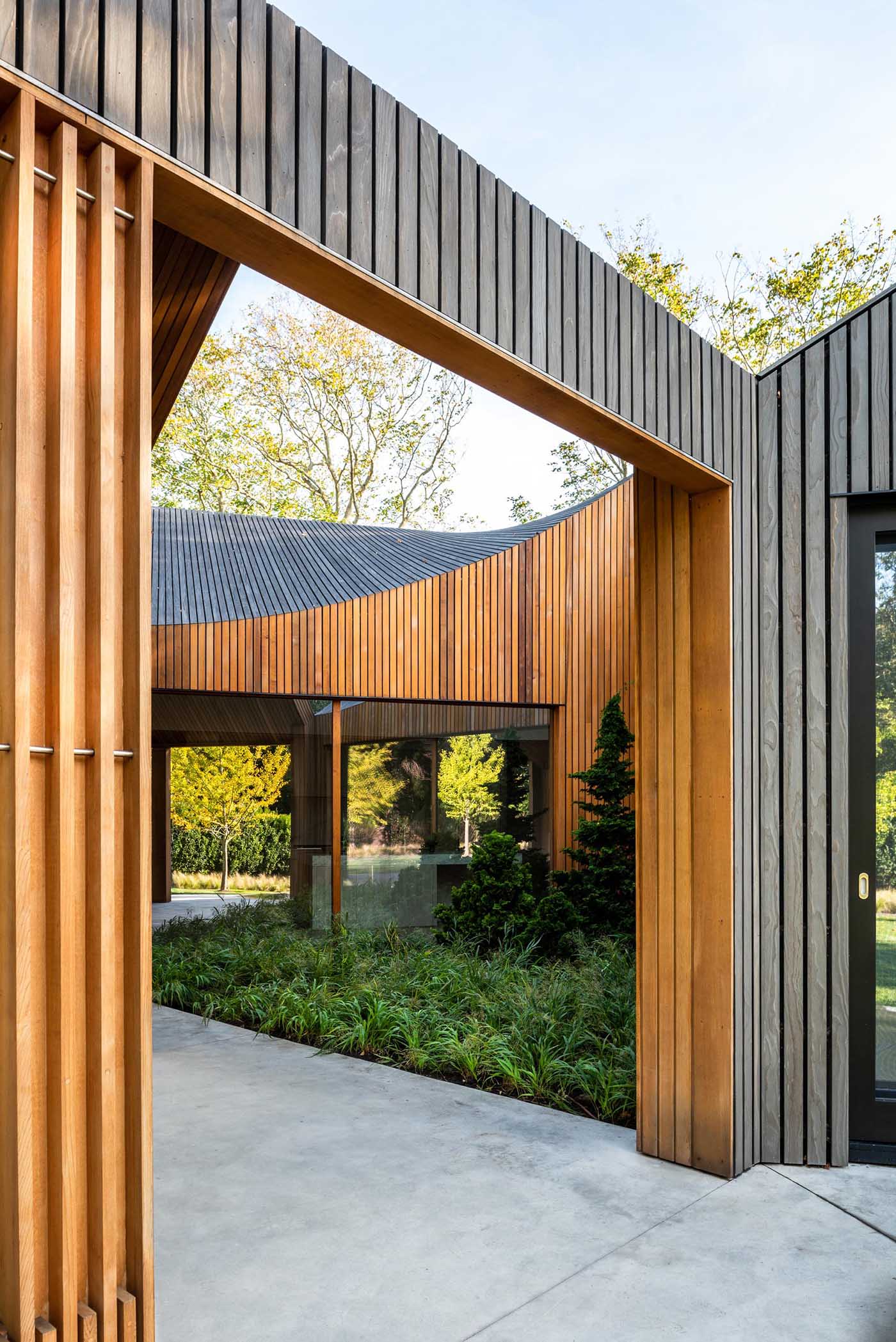 Ochre-hued cedar clads this home’s hybrid indoor/outdoor zones, such as the triangular courtyard and porch.