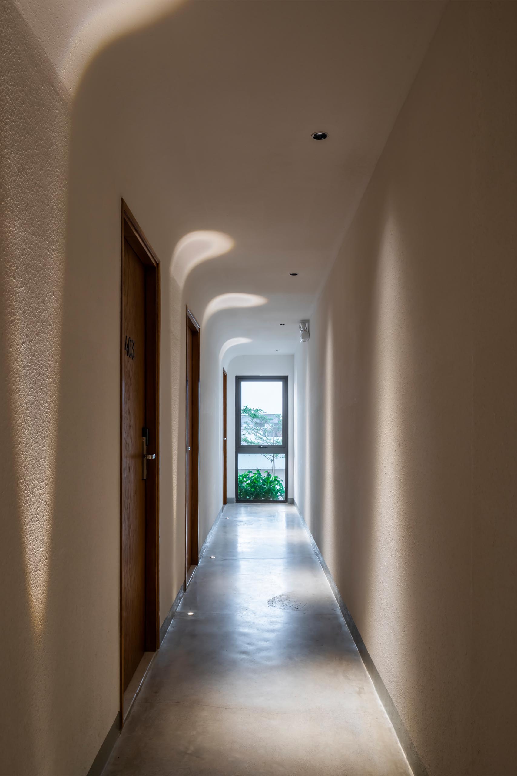 Bright hallways with lighting embedded in the concrete floors, and in the ceiling, guides guests to their private apartments.