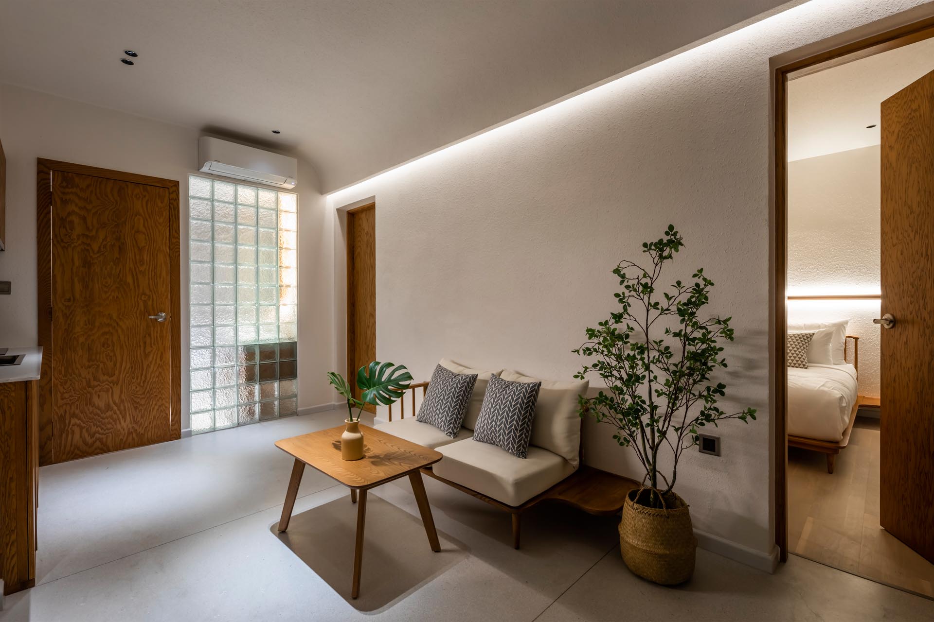 A minimalist apartment interior with LED lighting and a small living room.