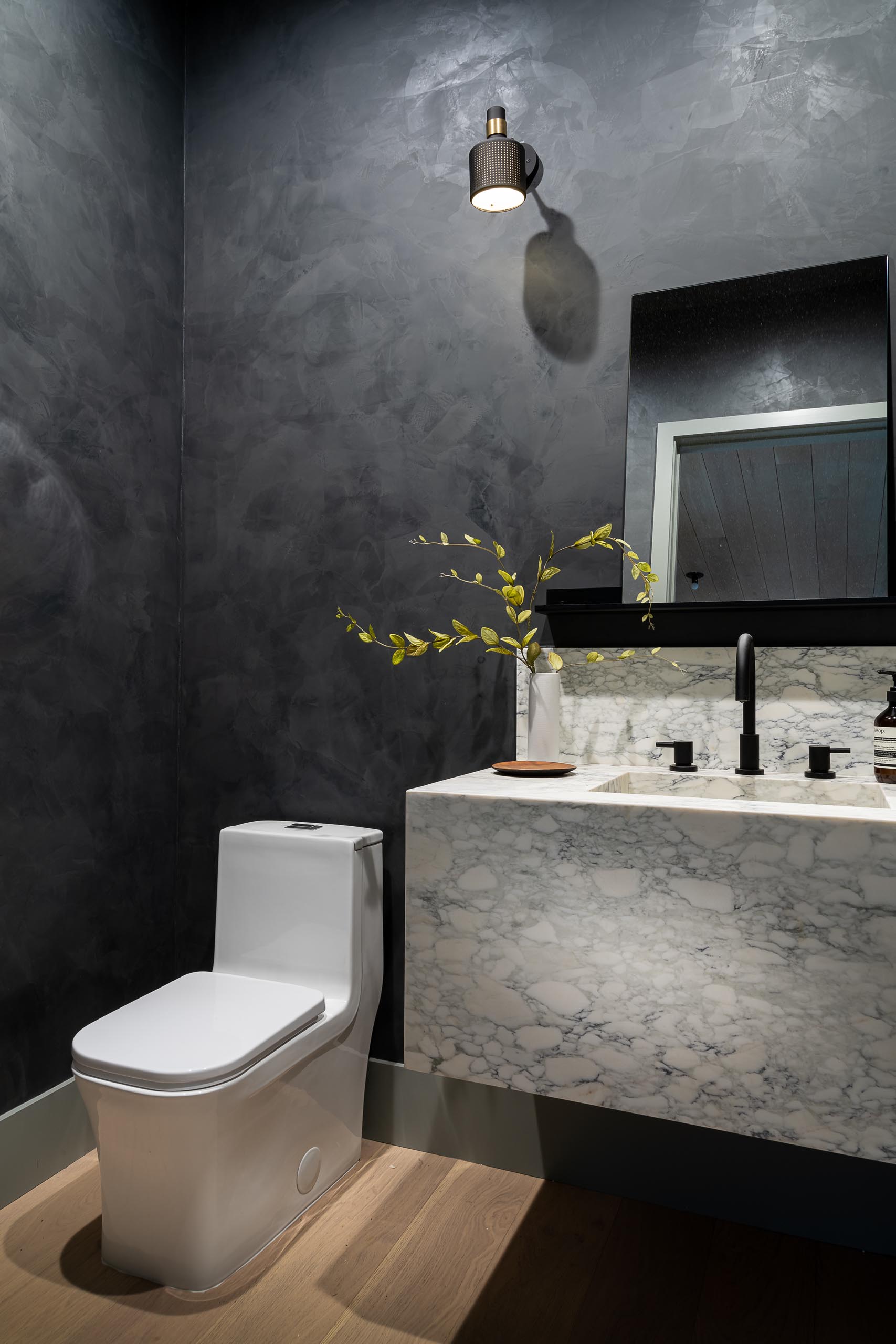 A modern bathroom with dark gray walls helps to create a dramatic look.