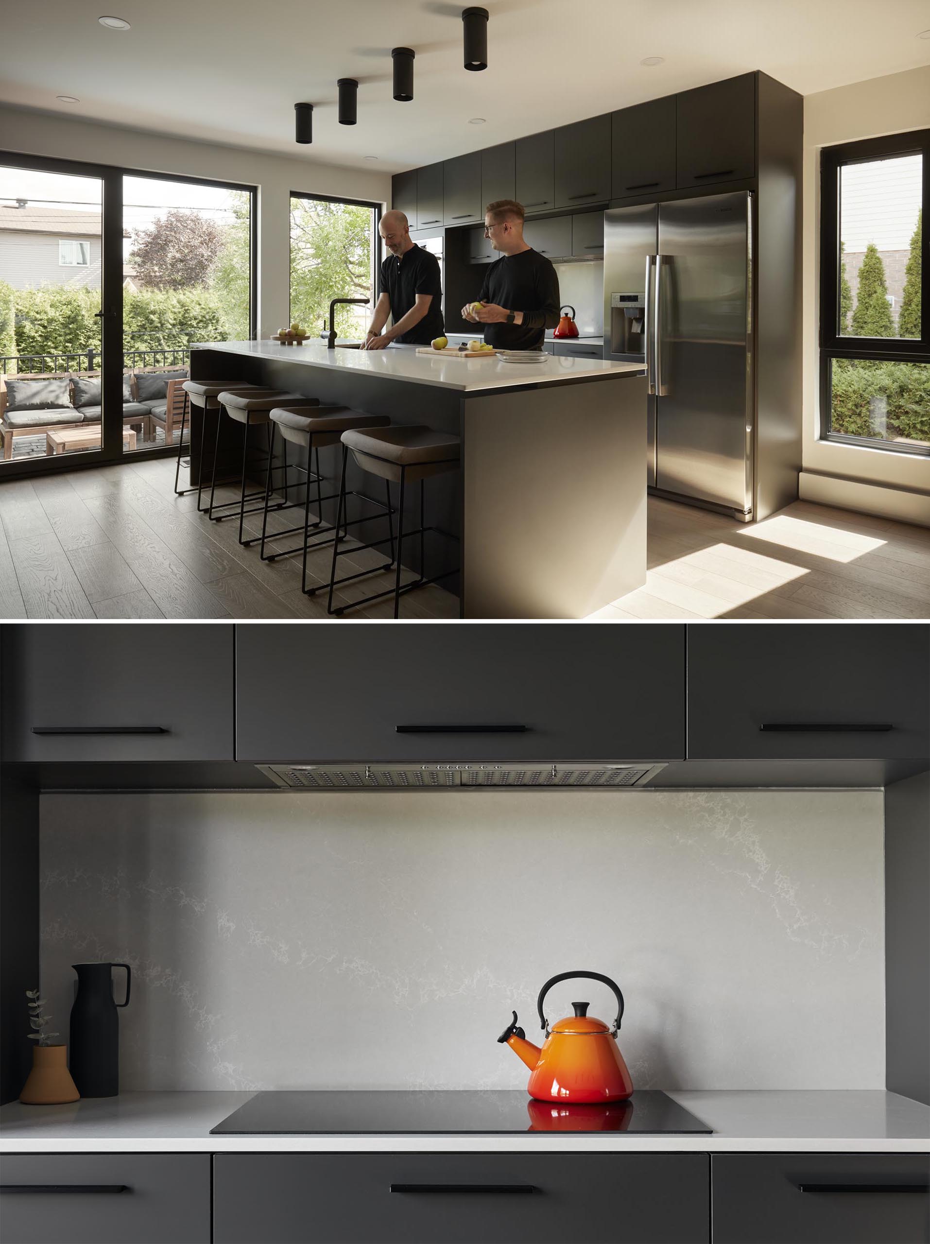 In this modern kitchen, two large blocks of integrated built-in cabinets face each other, with an island positioned between them.