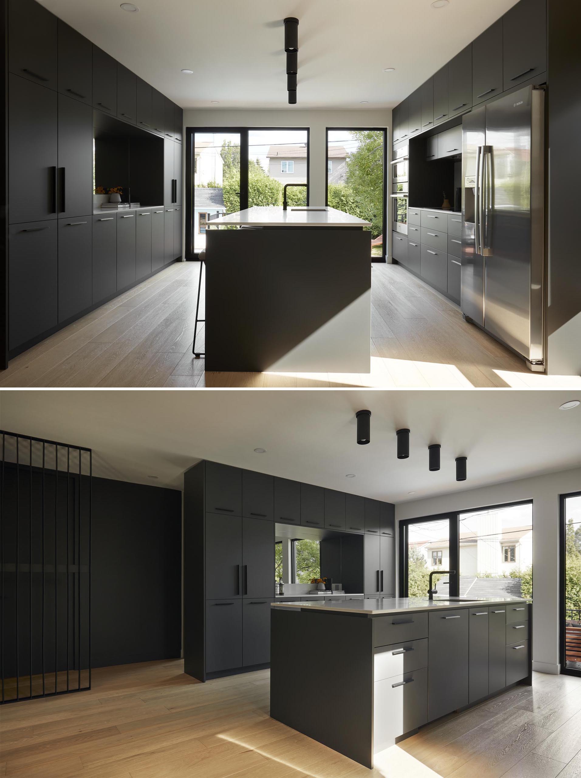 In this modern kitchen, two large blocks of integrated built-in cabinets face each other, with an island positioned between them.