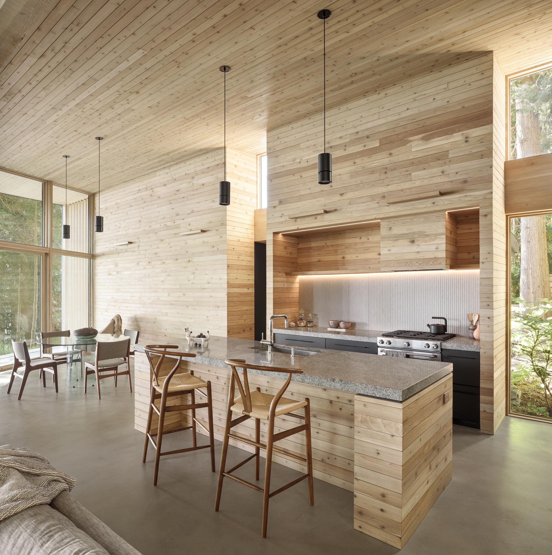 This modern kitchen lined with cedar,  has been designed with thick countertops, and dark lower cabinets.