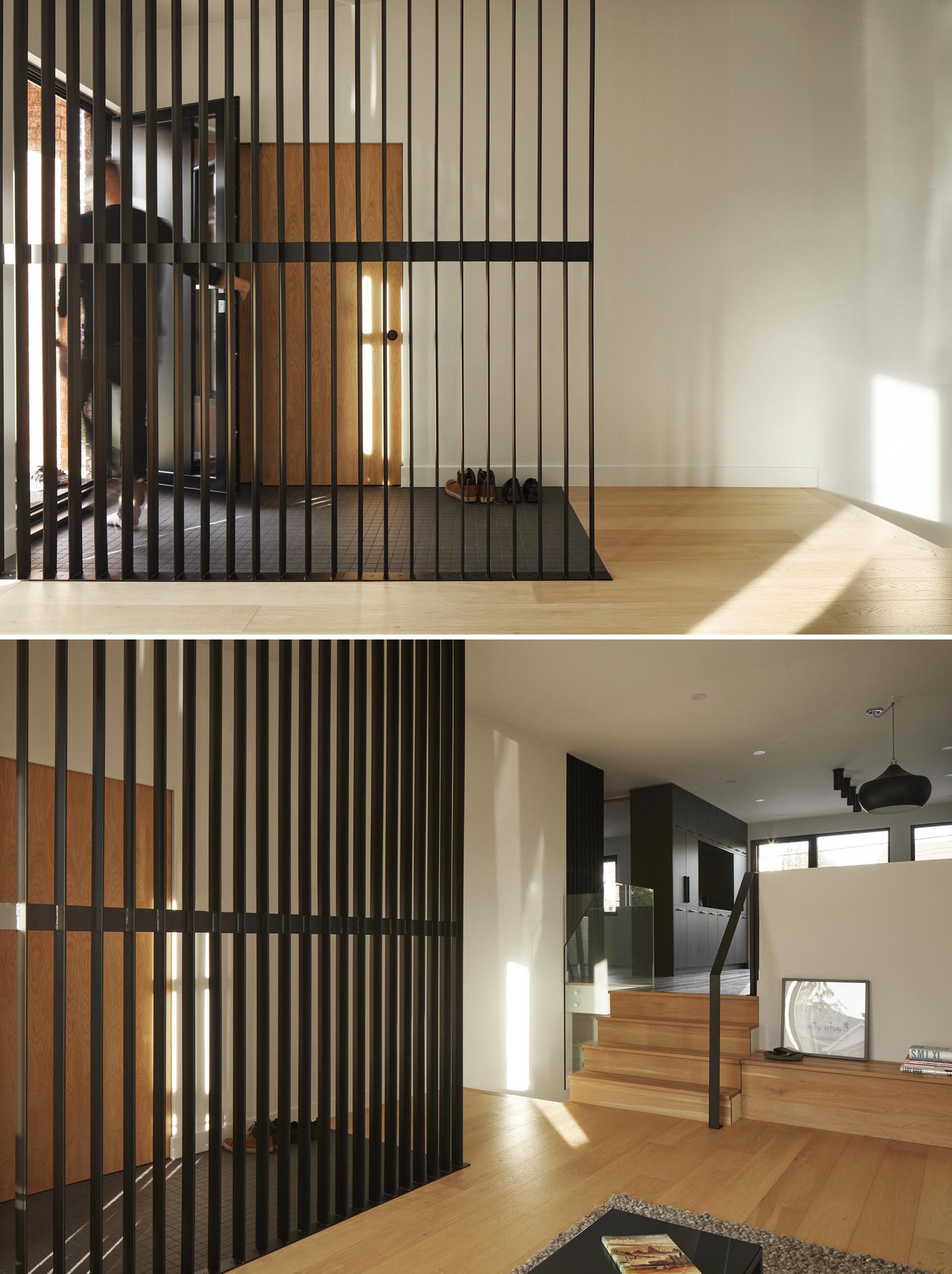 This modern room divider, which also complements the dark tiled floor, allows the light from the living room to travel through to the entryway.