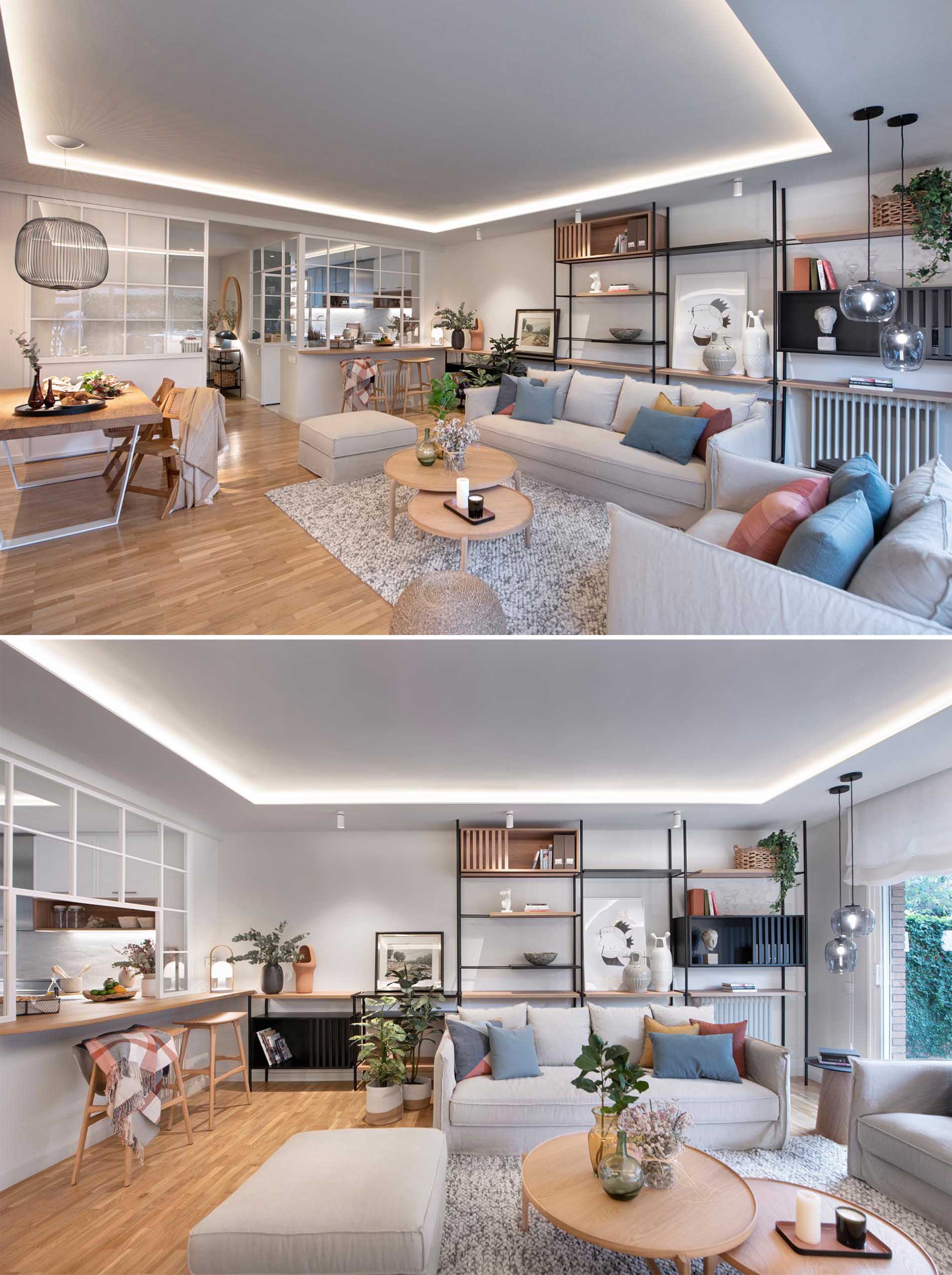 This modern open plan living room has shelving that lines the wall, while the couch and armchair are focused on the fireplace and built-in firewood storage.