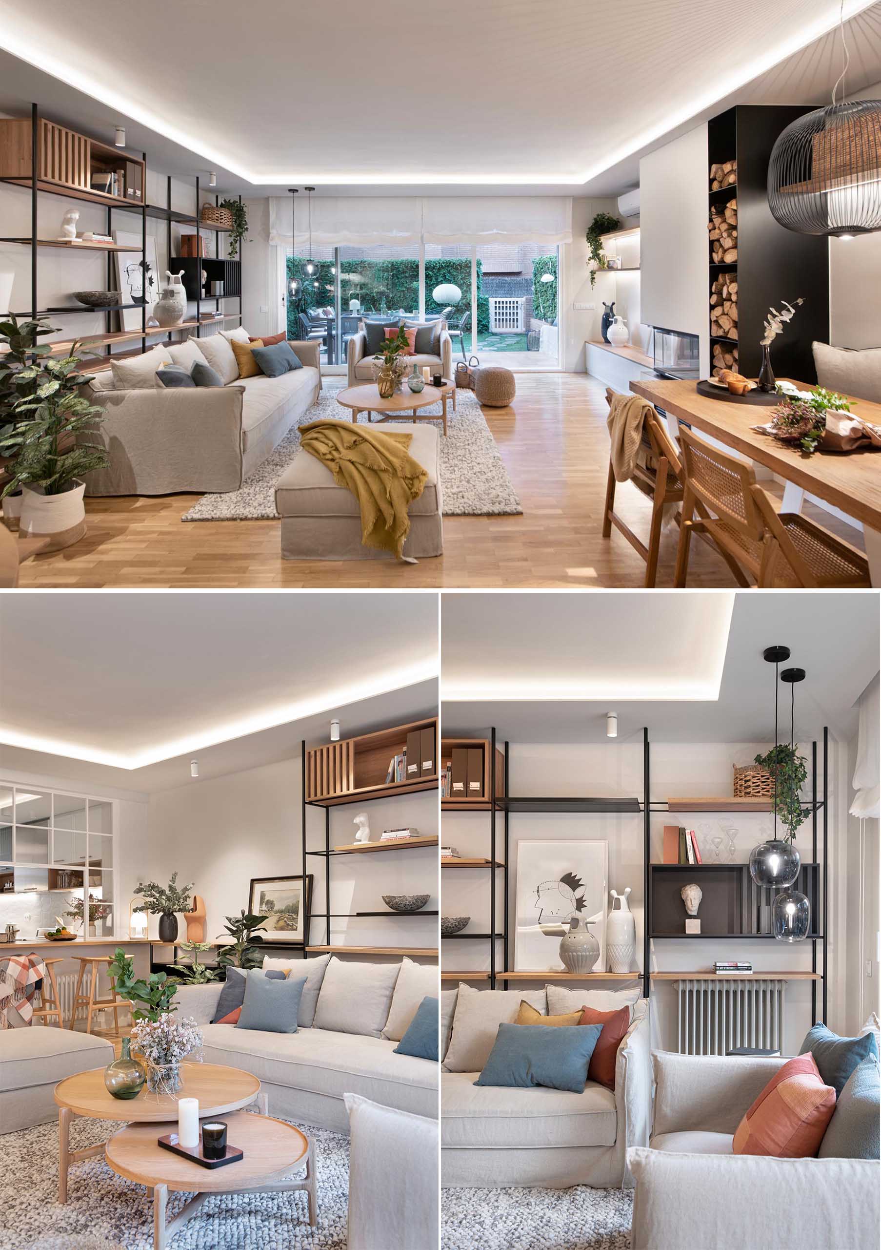 This modern open plan living room has shelving that lines the wall, while the couch and armchair are focused on the fireplace and built-in firewood storage.