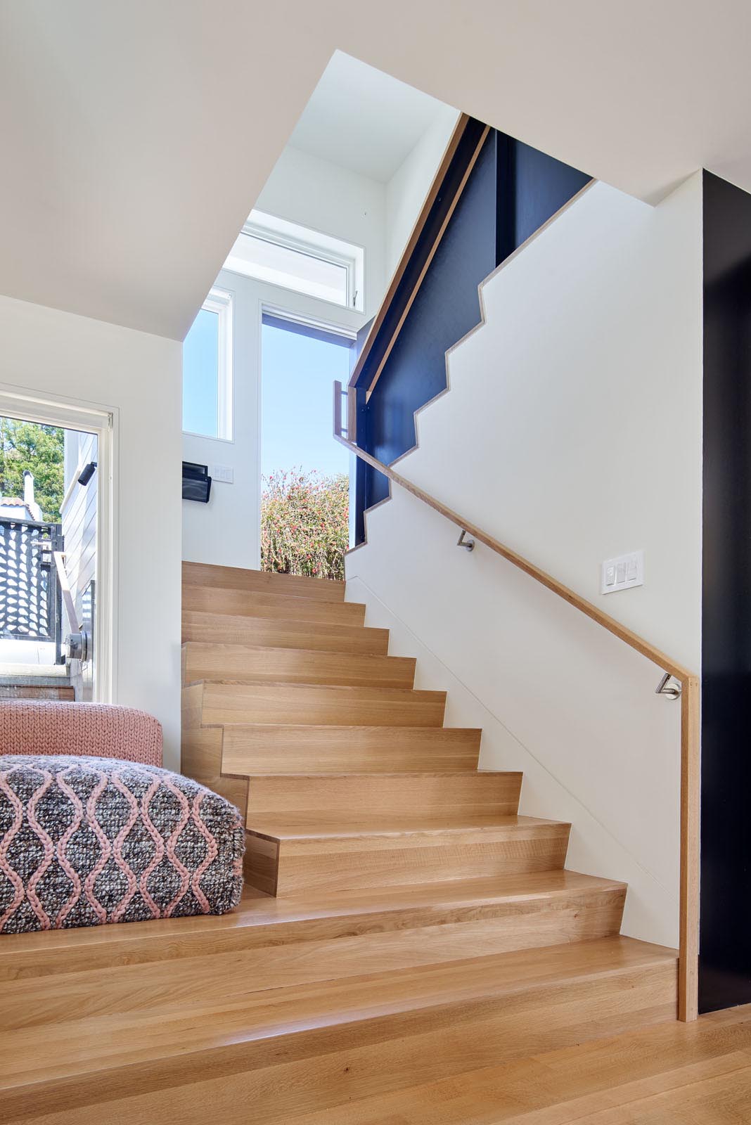 The contemporary entryway and wood stairs of a split-level home.