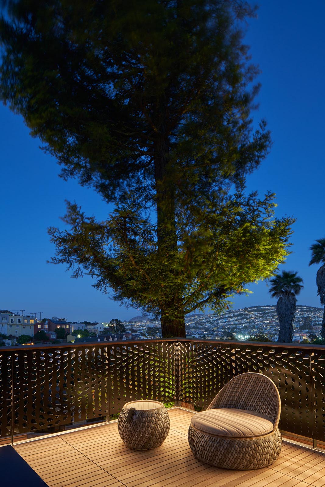 An outdoor deck with a guardrail that was inspired by the nearby conifer tree.