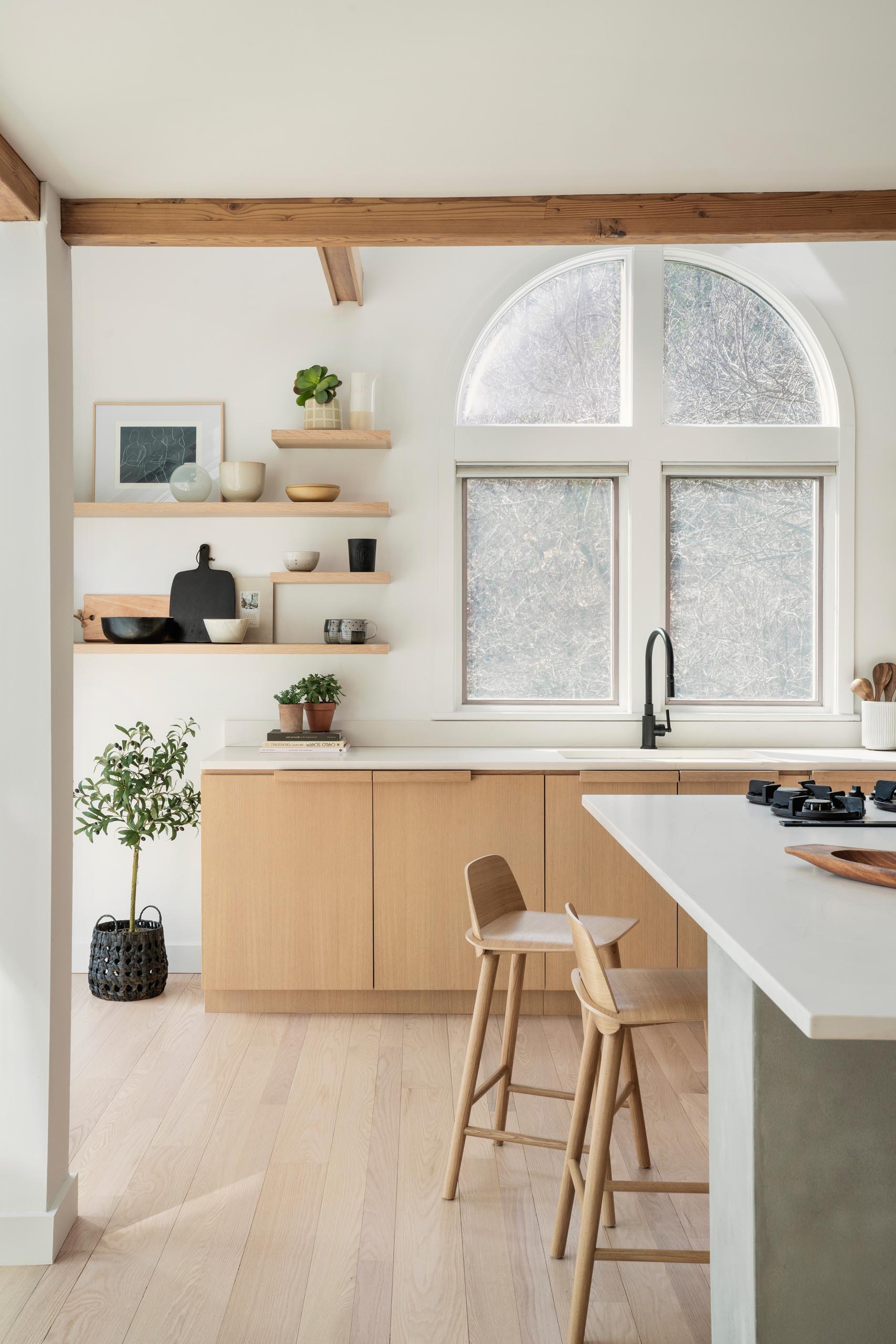 A remodeled kitchen with water-based white rift oak for the cabinets, open shelving, a large island, and quartz countertops.