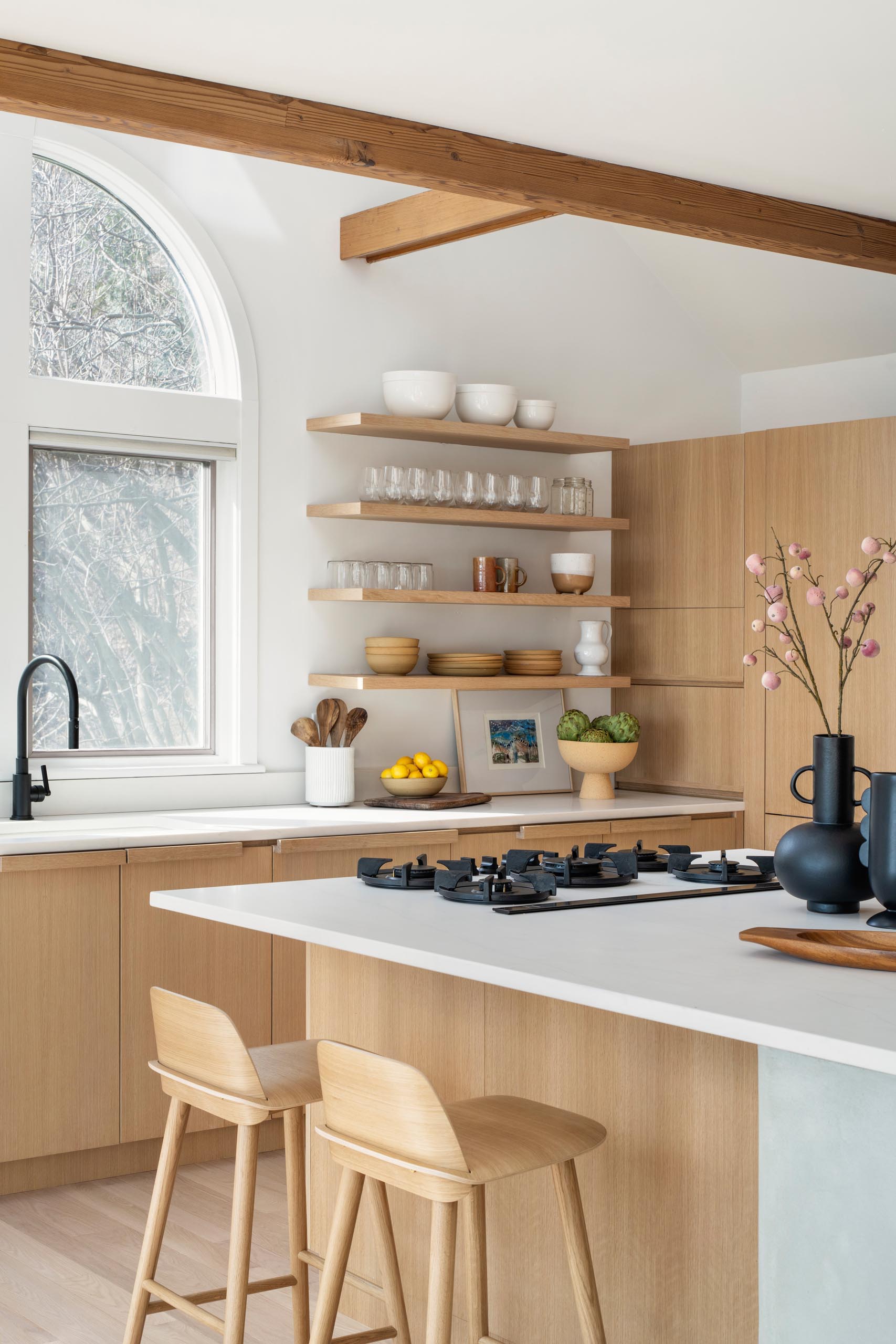 A remodeled kitchen with water-based white rift oak for the cabinets, open shelving, a large island, and quartz countertops.