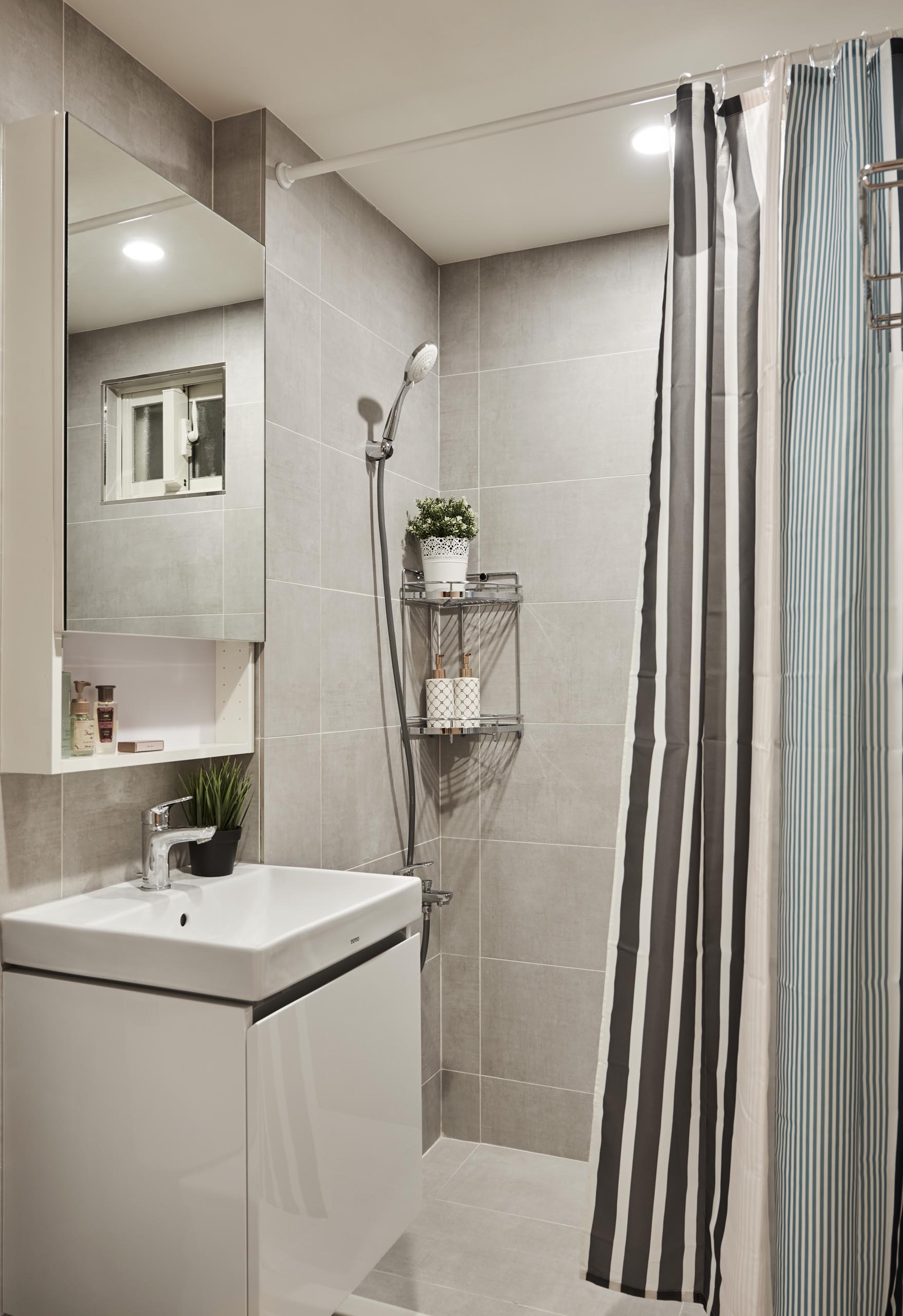 In this small bathroom, there's large format tiles that cover the walls and floors.