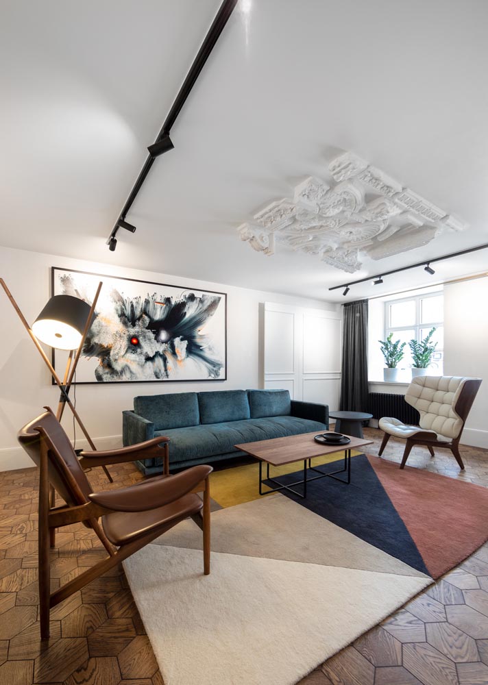 This apartment building common room has been designed with historical touches and modern furnishings, which provide spaces to meet and mingle with other residents.
