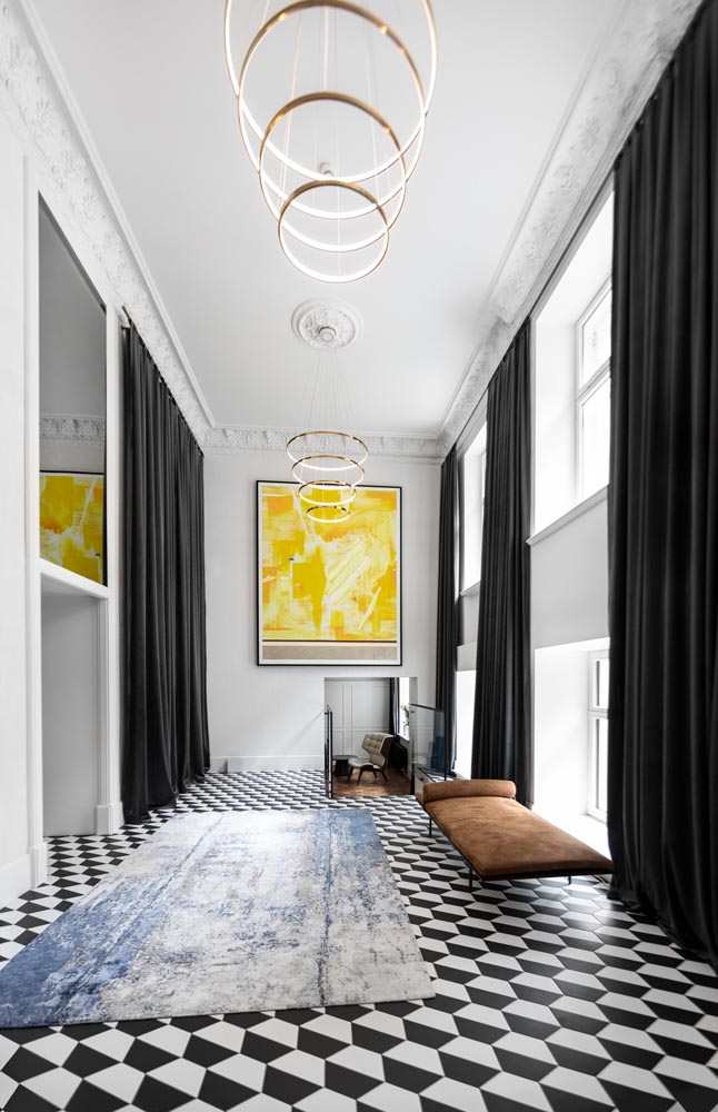 Bold patterned floors create eye-catching black and white elements throughout an apartment building.