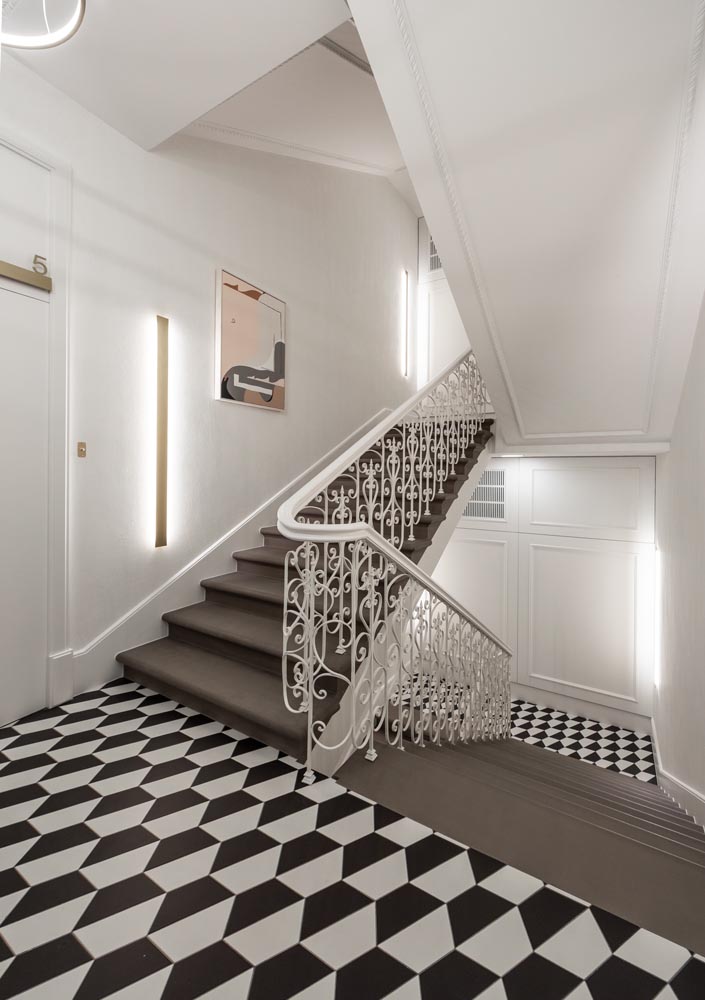 Bold patterned floors create eye-catching black and white elements throughout an apartment building.