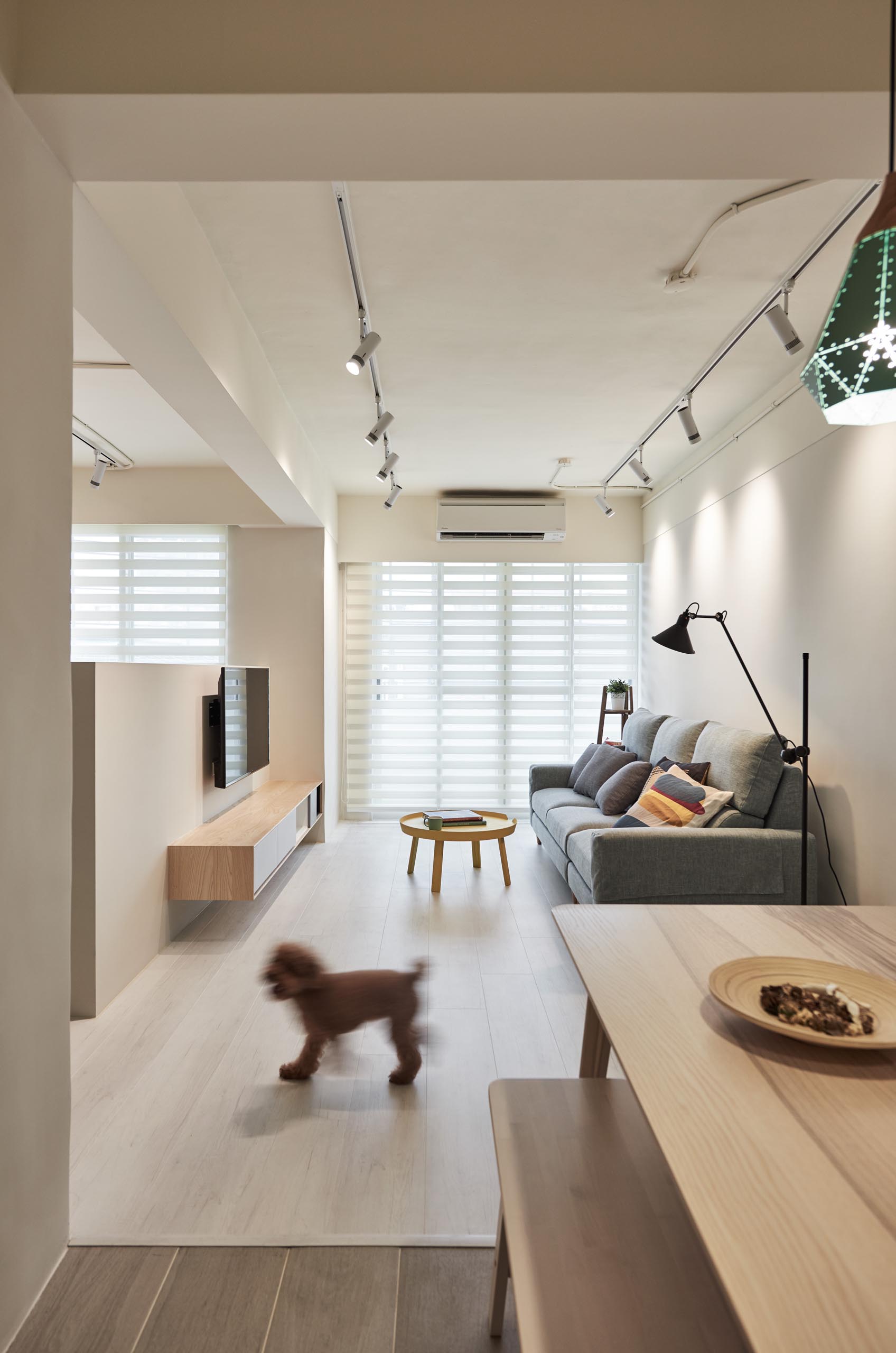 The living room receives an abundance of natural light from the large windows, while track lighting allows light to be directed at different areas of the room.