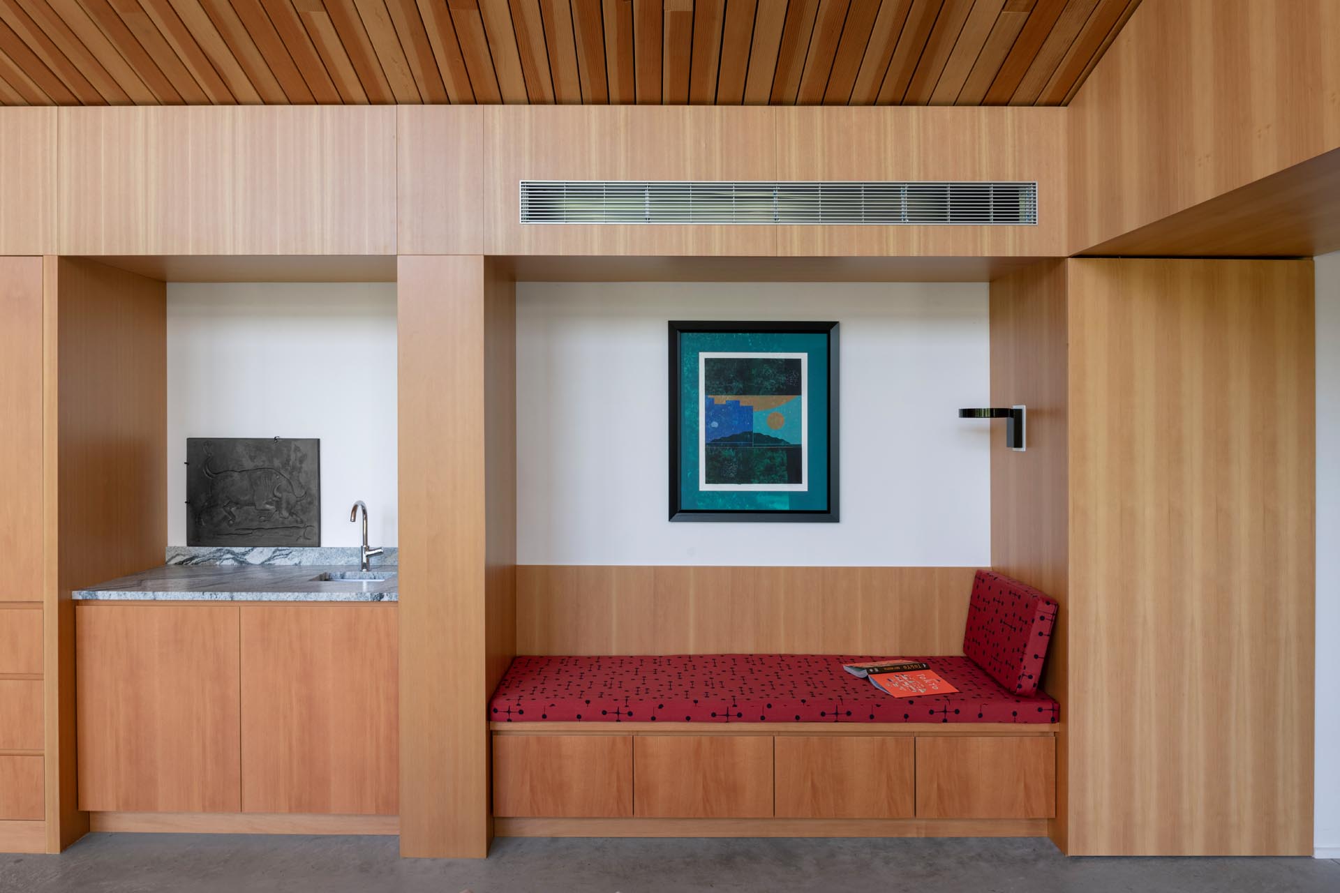 A modern home interior with a built-in bench and small wet bar.