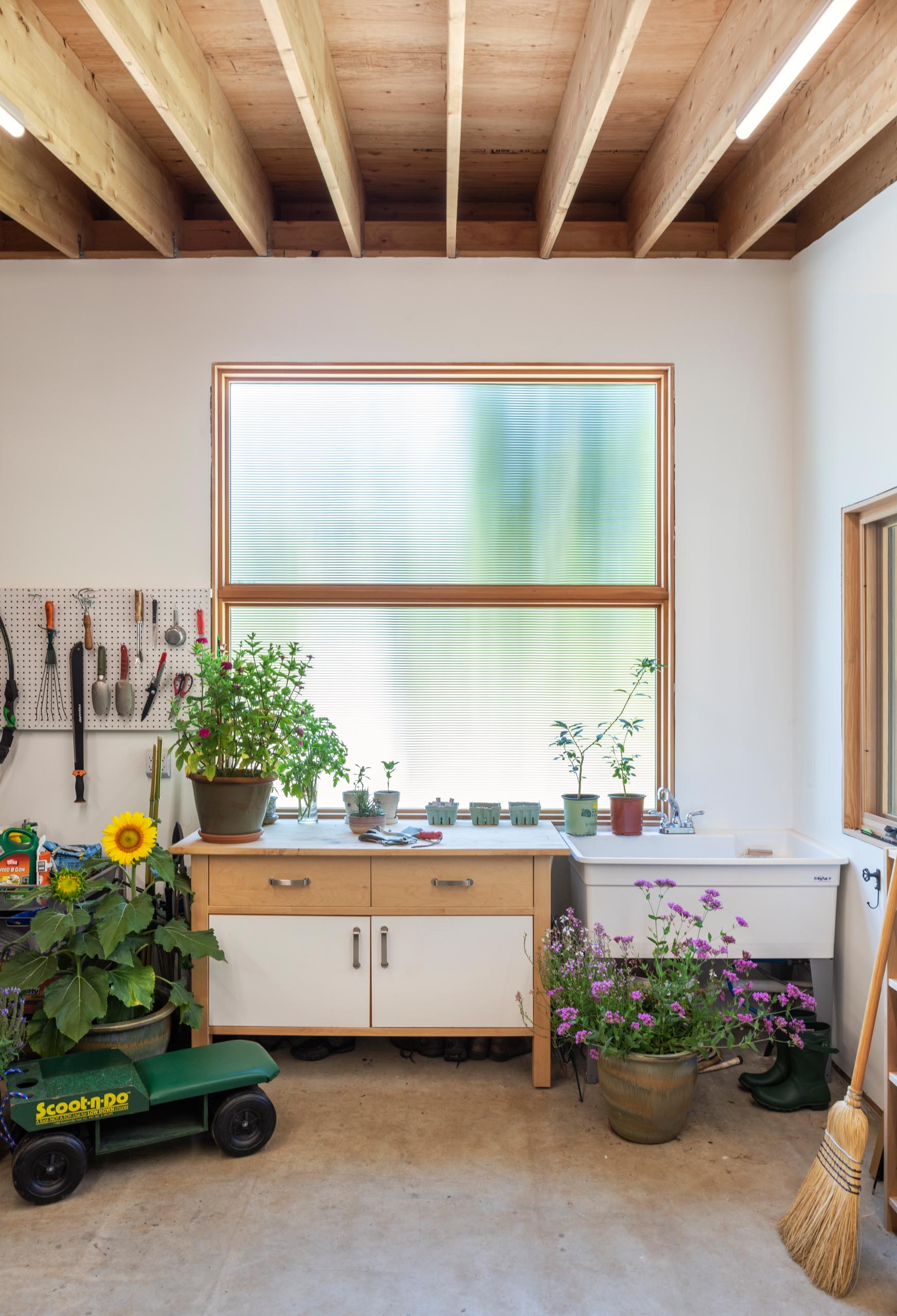 A potting shed with tool storage, work bench and a sink.