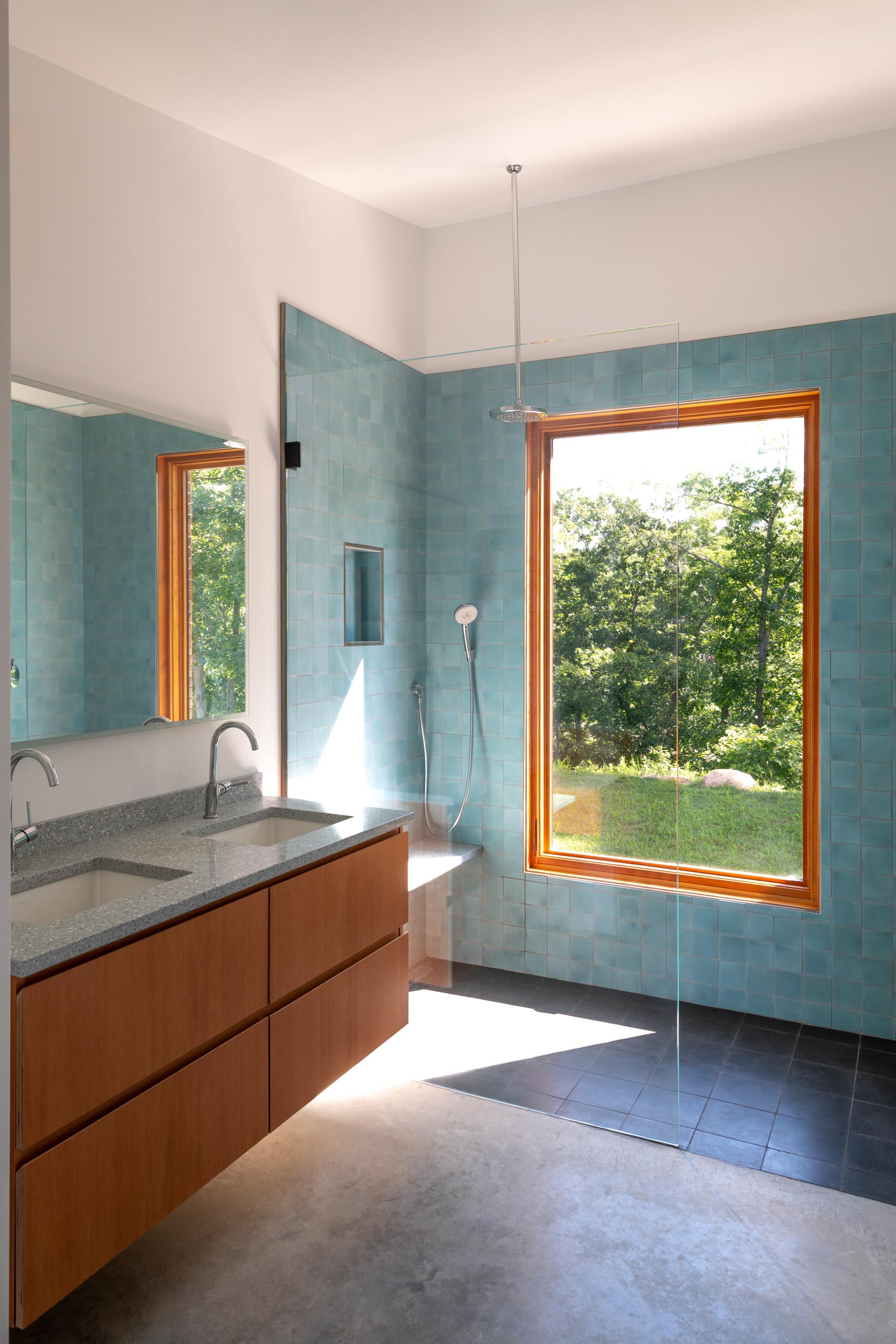 A modern bathroom with square blue accent tiles that covered the shower walls.