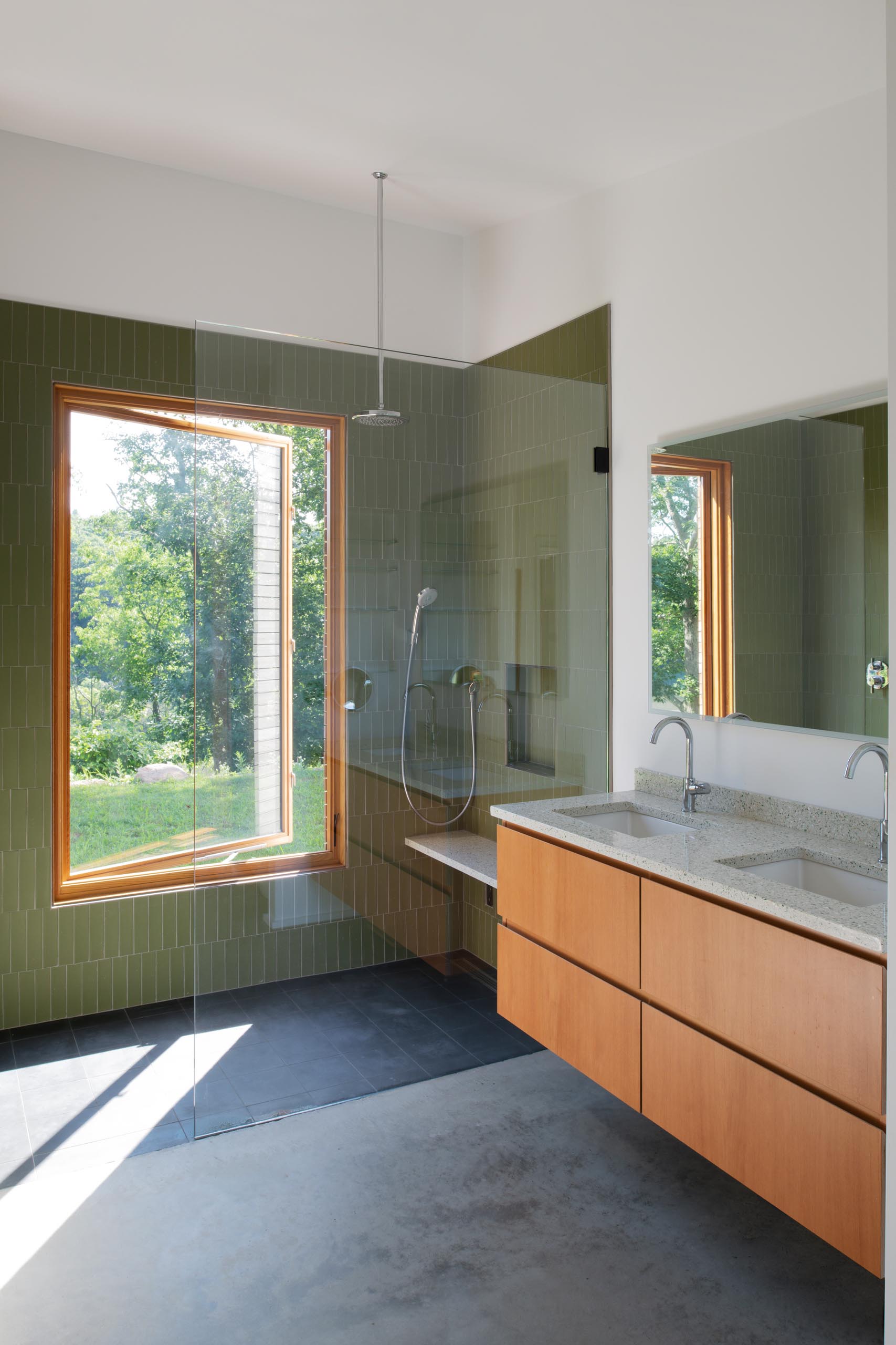 A modern bathroom with green accent tiles that covered the shower walls.