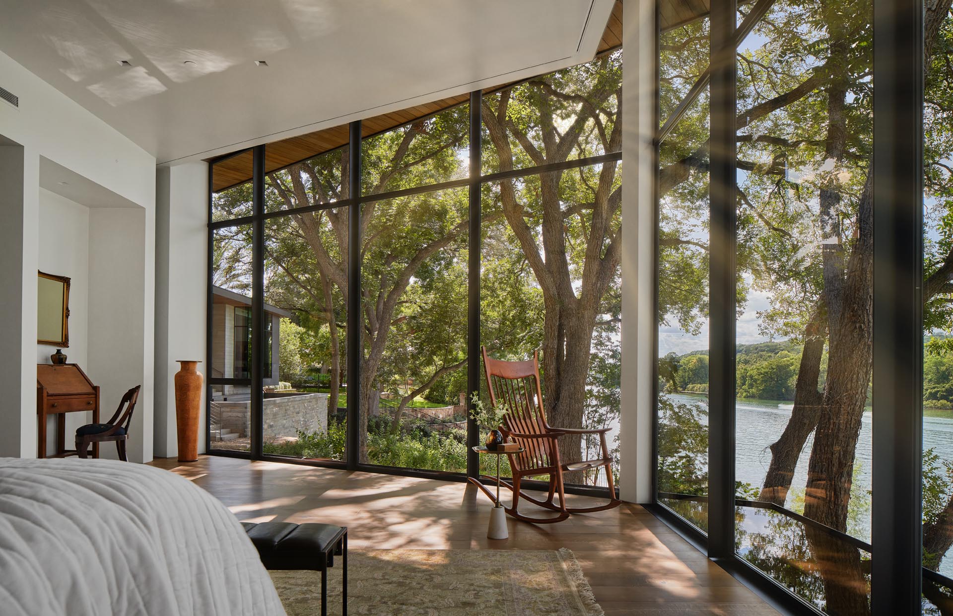 This primary bedroom has a hexagonal layout and 180 degree views of the lake through the floor-to-ceiling windows.