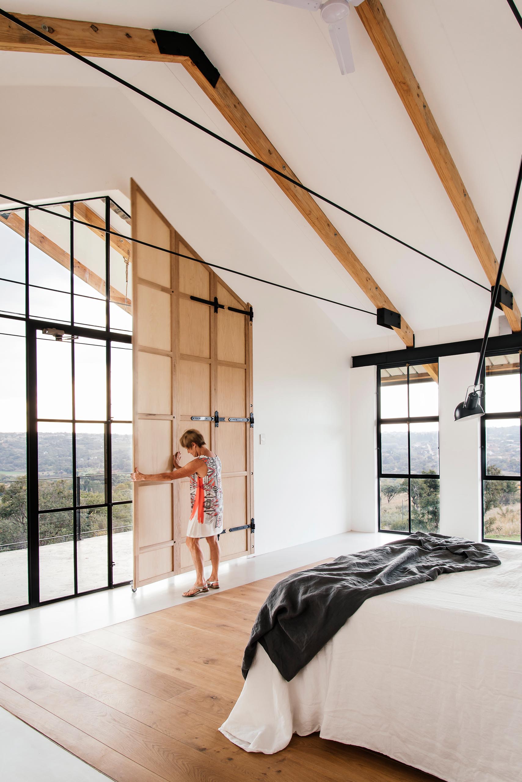 This primary bedroom is minimally furnished and positioned to enjoy bird watching into the tree canopy and sunset views. The large overhanging patio and timber shutters assist in eliminating unwanted afternoon sun.