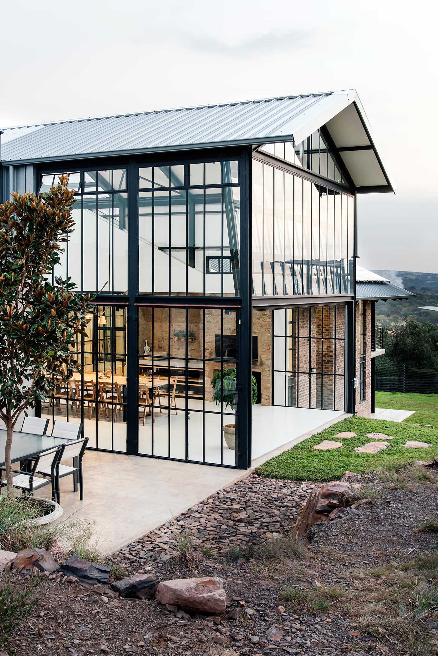 The double-height conservatory can be opened, providing uninterrupted views of the landscape, while a glass section flooring gives a glimpse of the lower level below.