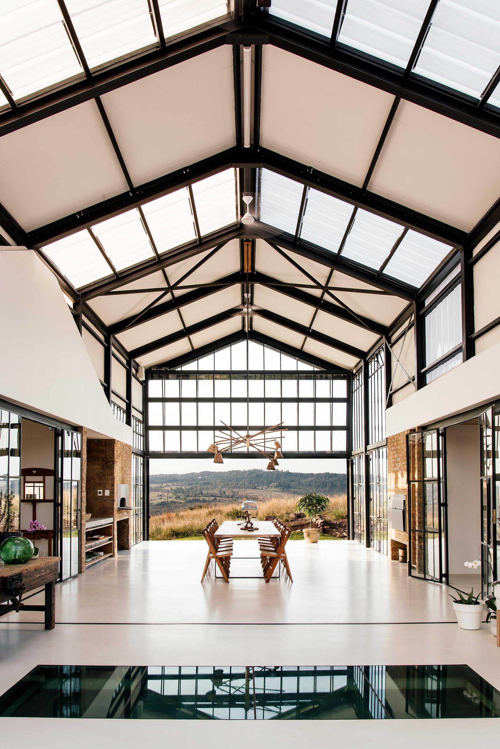 The double-height conservatory can be opened, providing uninterrupted views of the landscape, while a glass section flooring gives a glimpse of the lower level below.