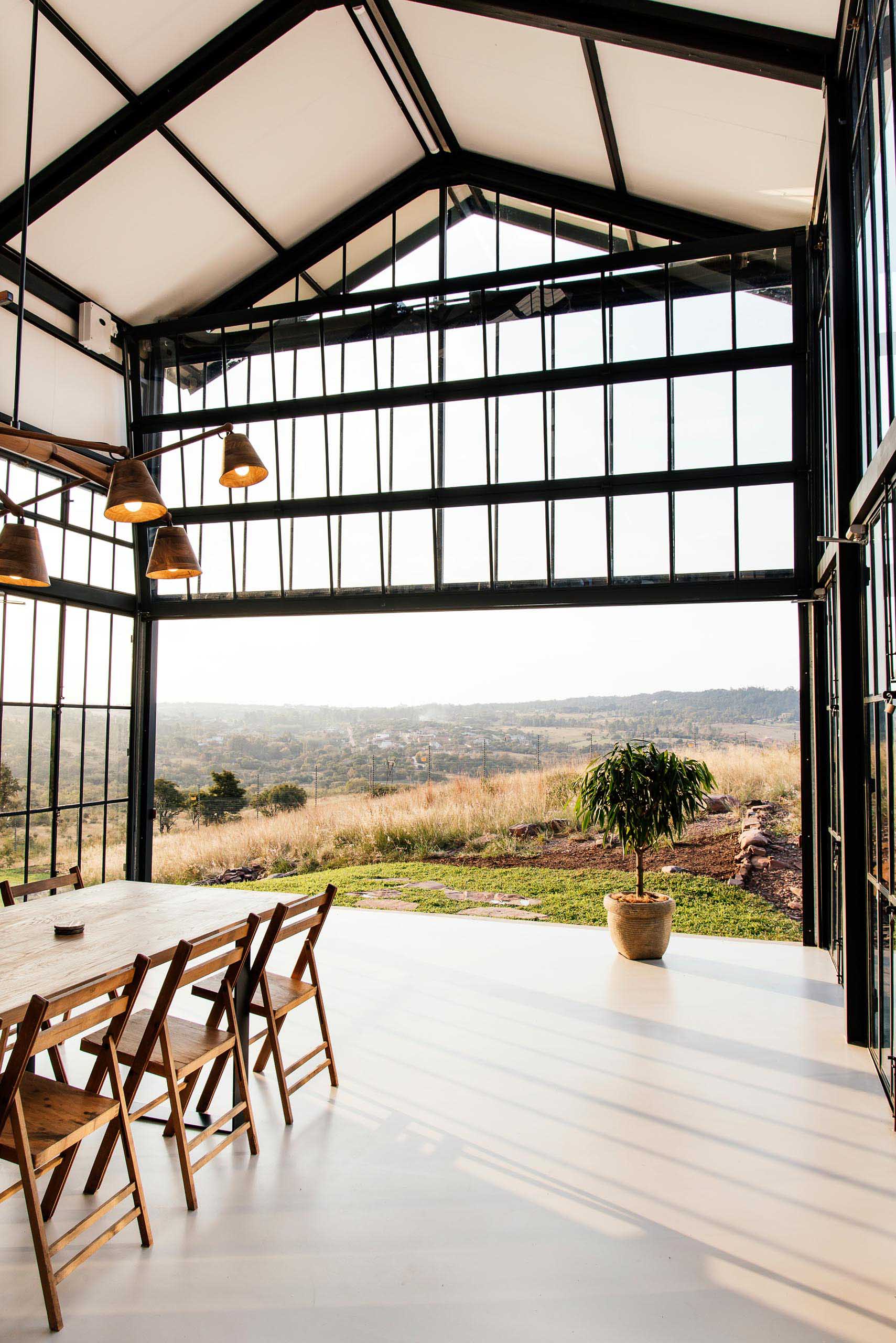 The double-height conservatory can be opened, providing uninterrupted views of the landscape, while a glass section flooring gives a glimpse of the lower level below.