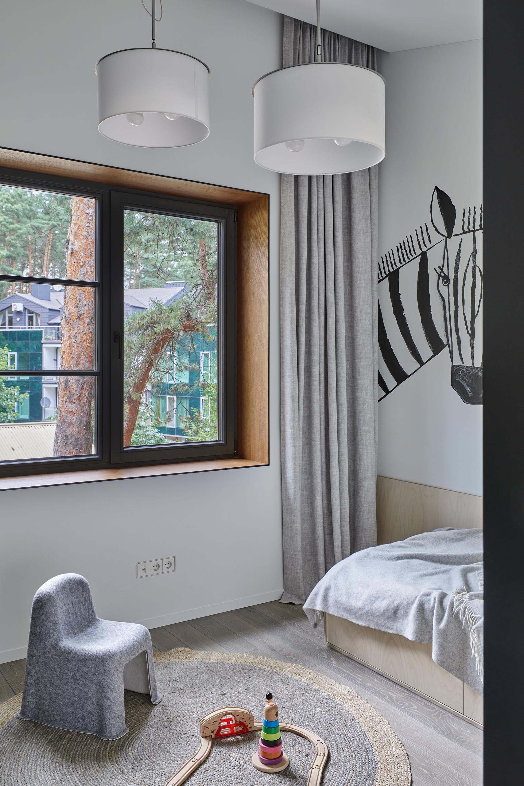 In this modern kid's bedroom, there's a zebra art feature, as well as a colorful yellow shelf and a green desk surrounded by storage.