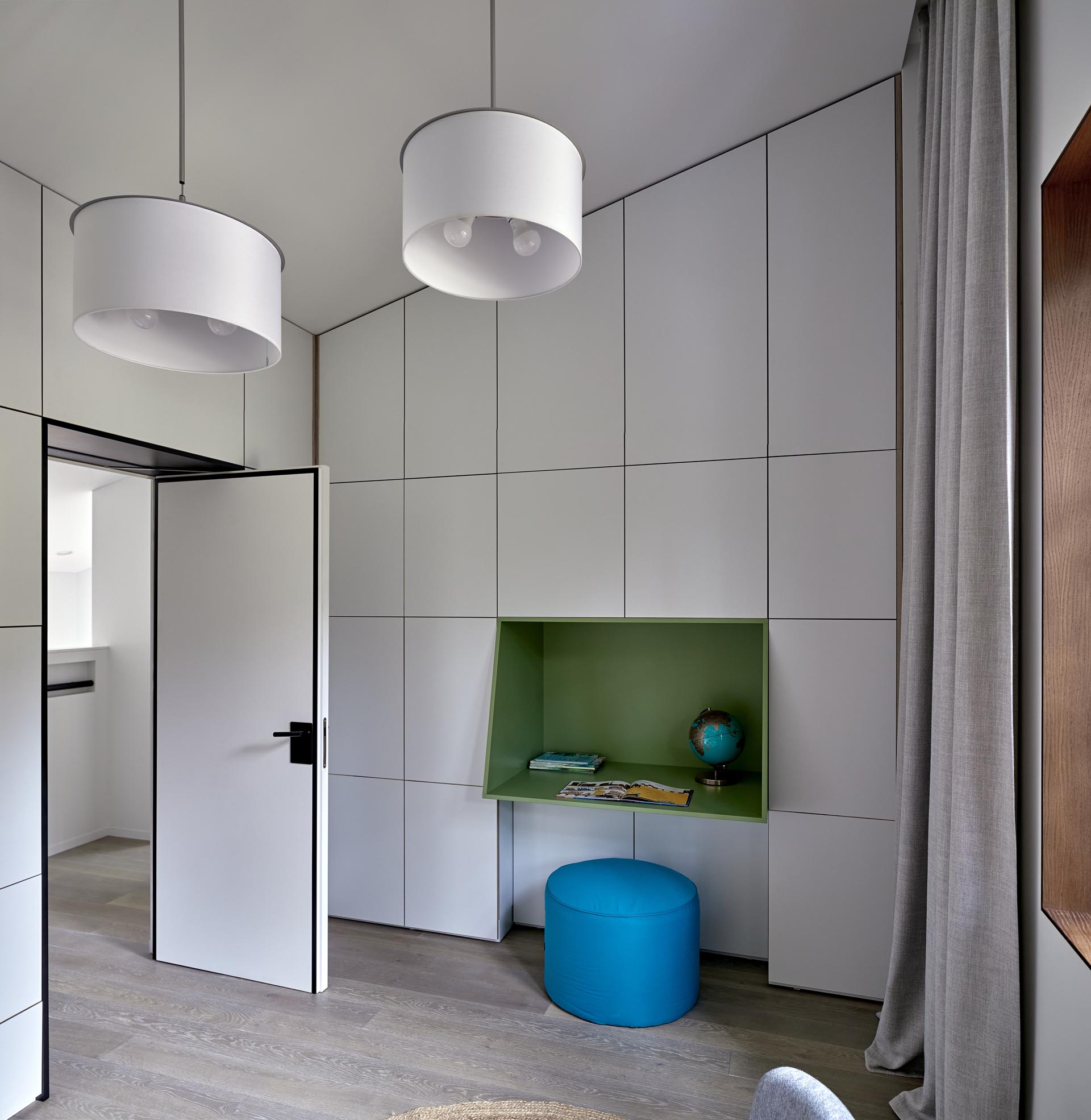 In this modern kid's bedroom, there's a zebra art feature, as well as a colorful yellow shelf and a green desk surrounded by storage.