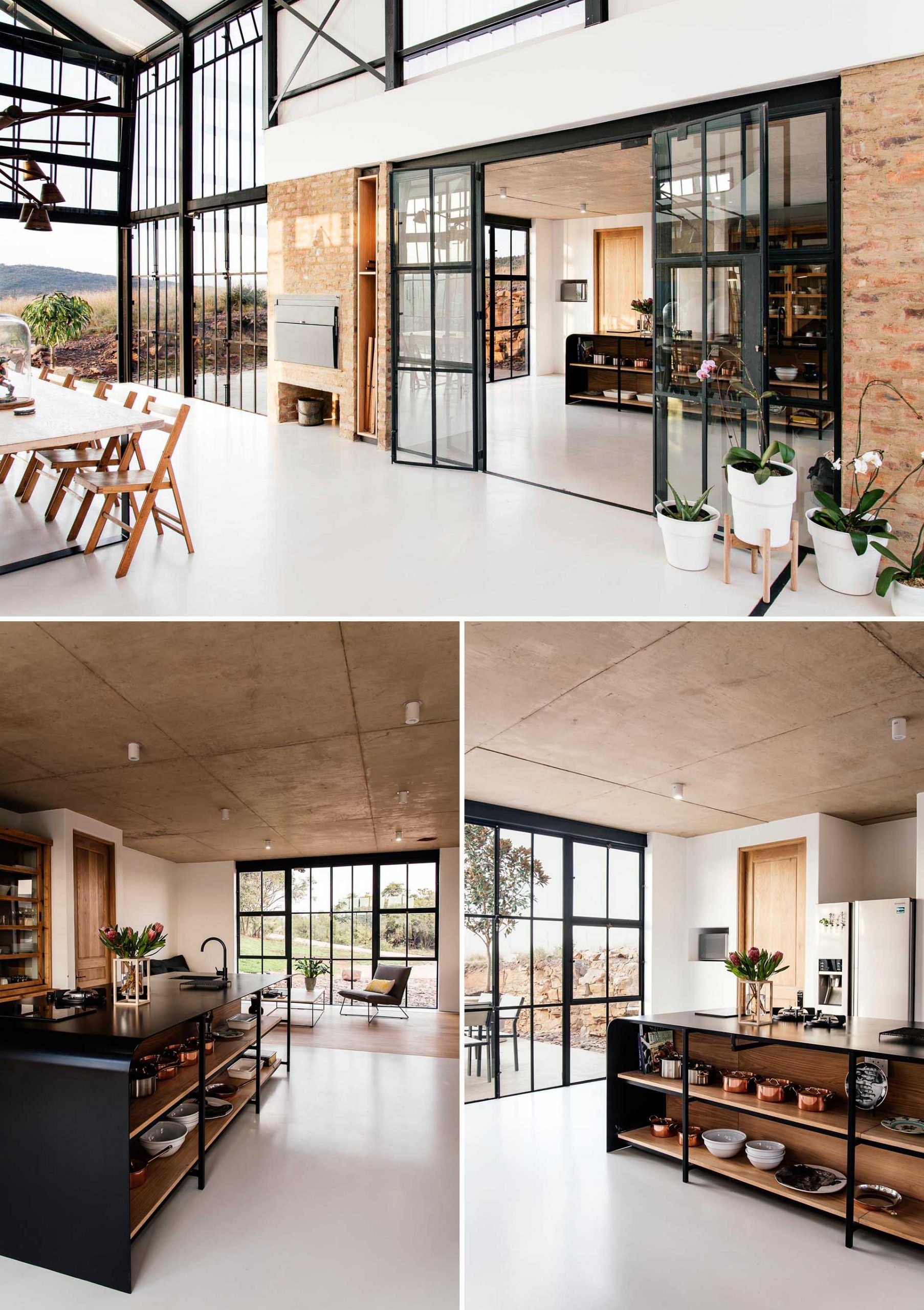 Black-framed glass doors open the conservatory to the kitchen, where a black island has open wood shelving to display pots, pans, and serving dishes. 