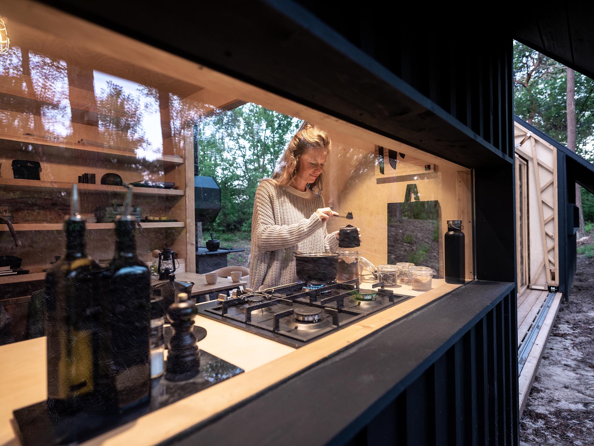 A versatile small and modern wood cabin with two different ‘shells’ as outer walls, which are supported on rails, allowing the interior to be open to the outdoors.