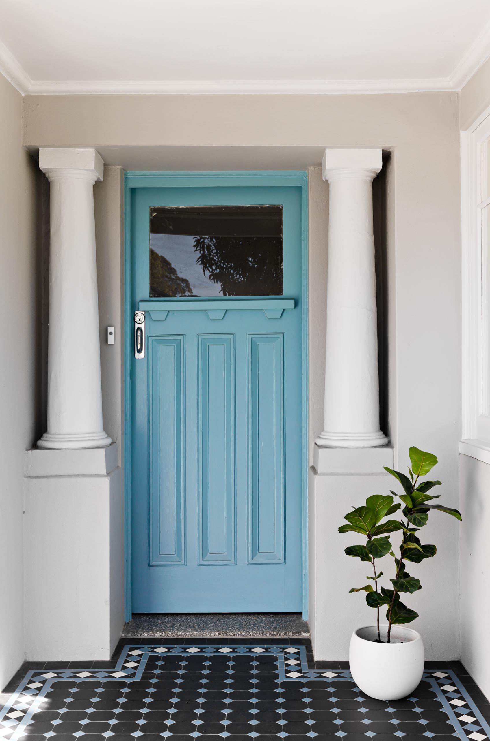 A renovated home with a brick blue front door.