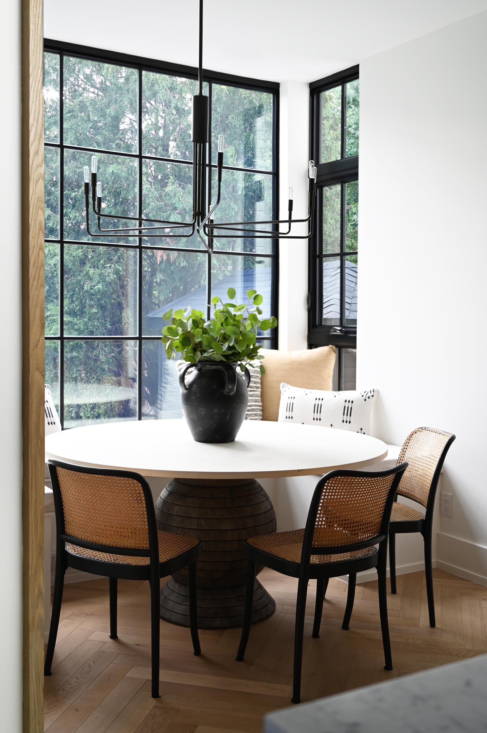 In this modern breakfast nook, the black window frames match the pendant light and the chair frames.