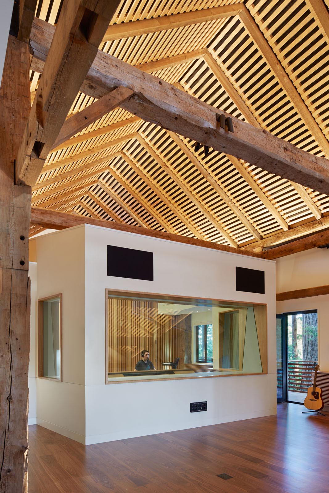 The interior of this modern recording studio includes a large open space with room for multiple instruments, as well as private recording rooms and a sound booth.