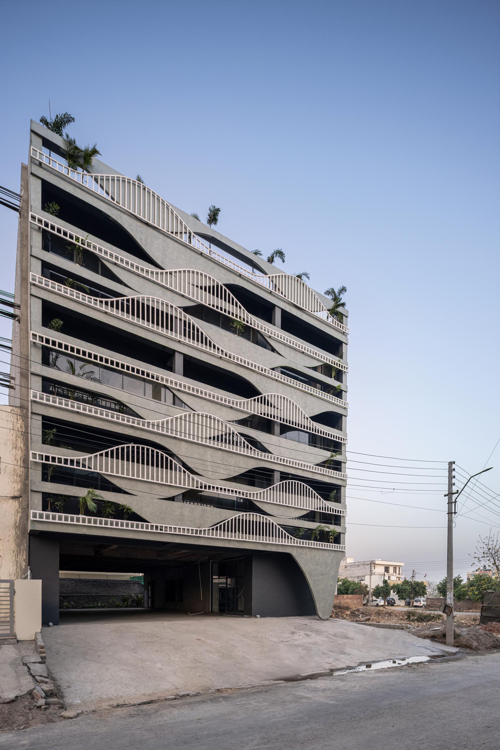 A unique building facade that's designed to look like melting concrete, with complimentary balcony railings.