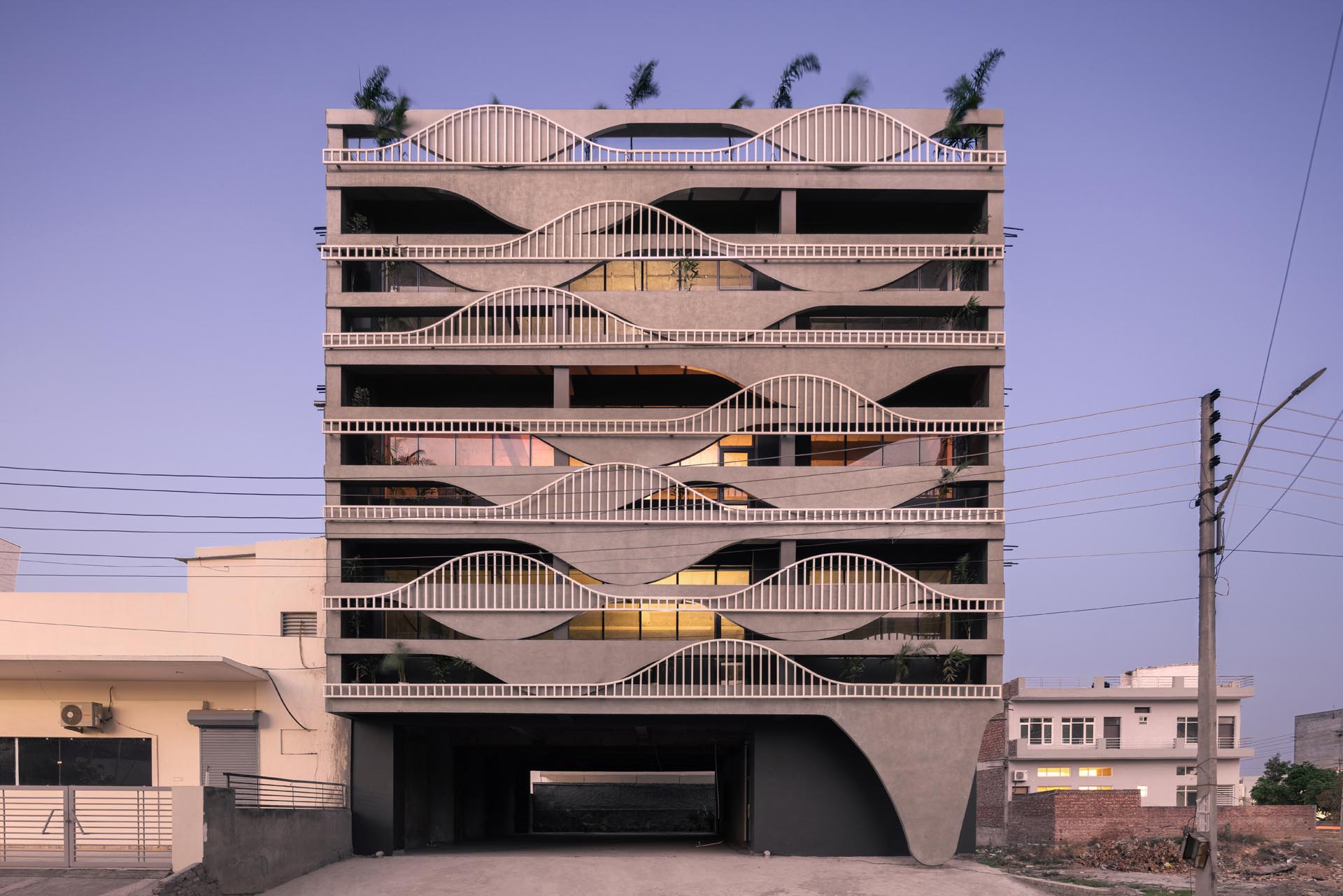 A unique building facade that's designed to look like melting concrete, with complimentary balcony railings.